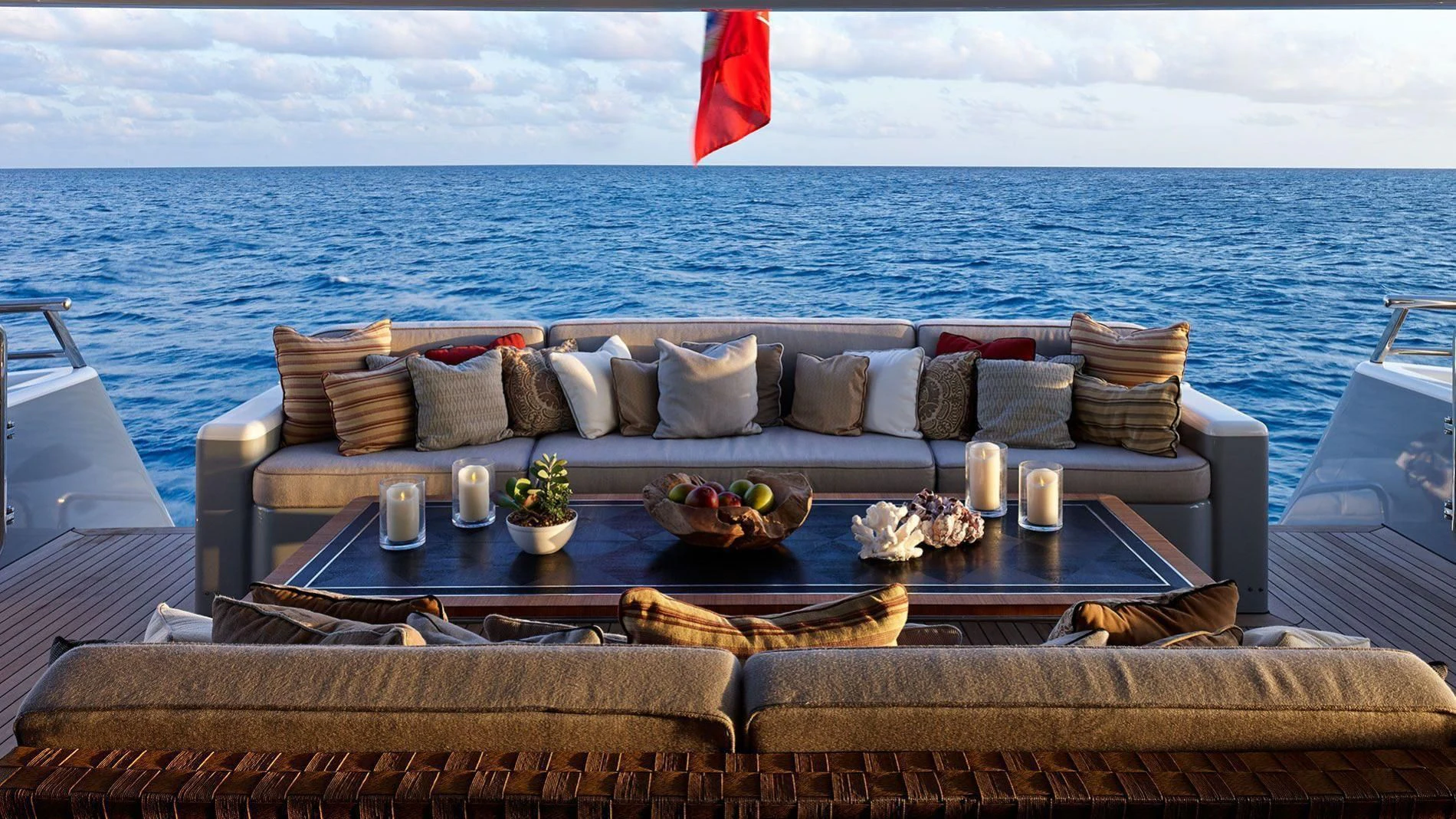 a couch with a table on it by the ocean aboard LIND Yacht for Charter