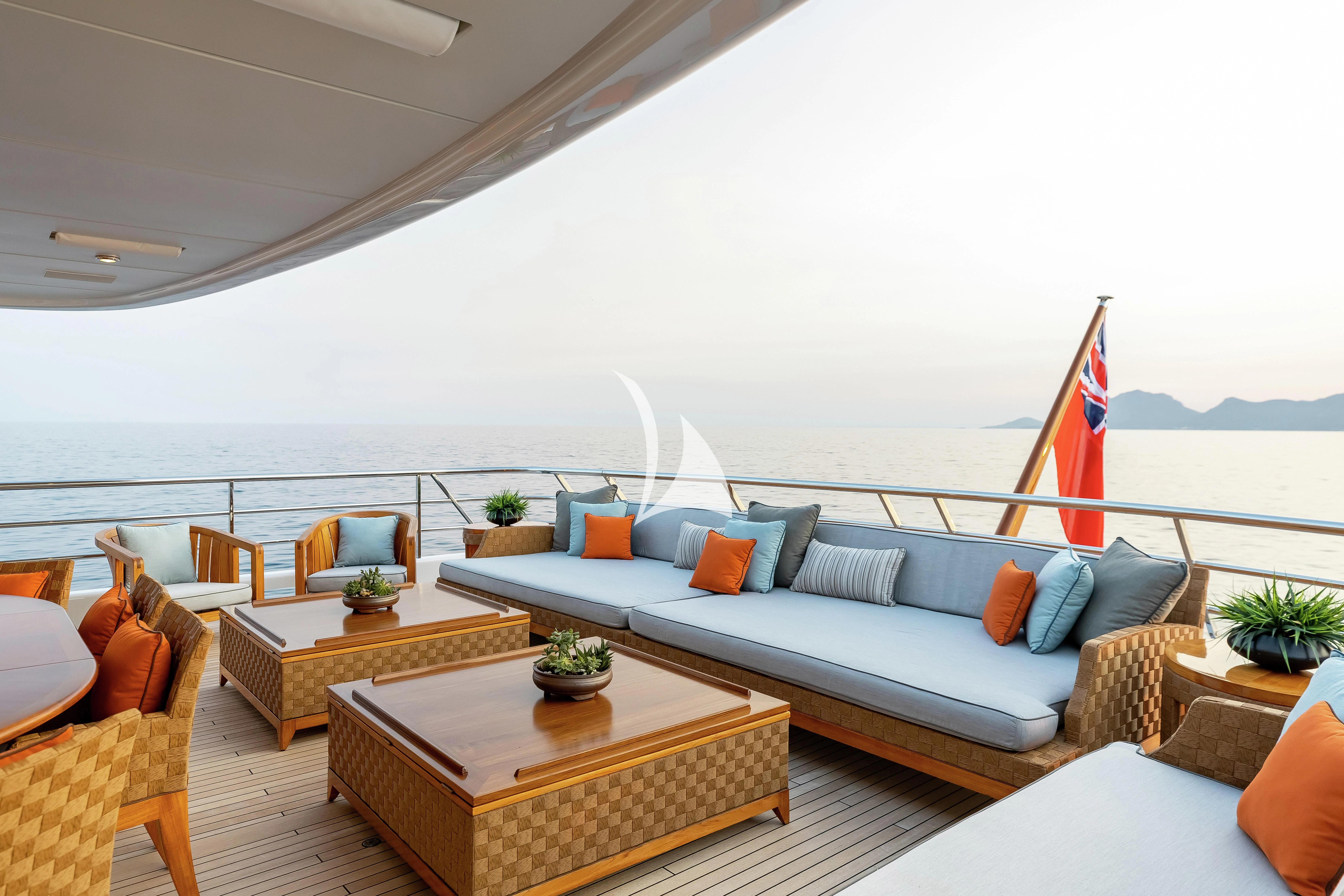 a living room with a large white sofa and a large flag aboard LIND Yacht for Charter