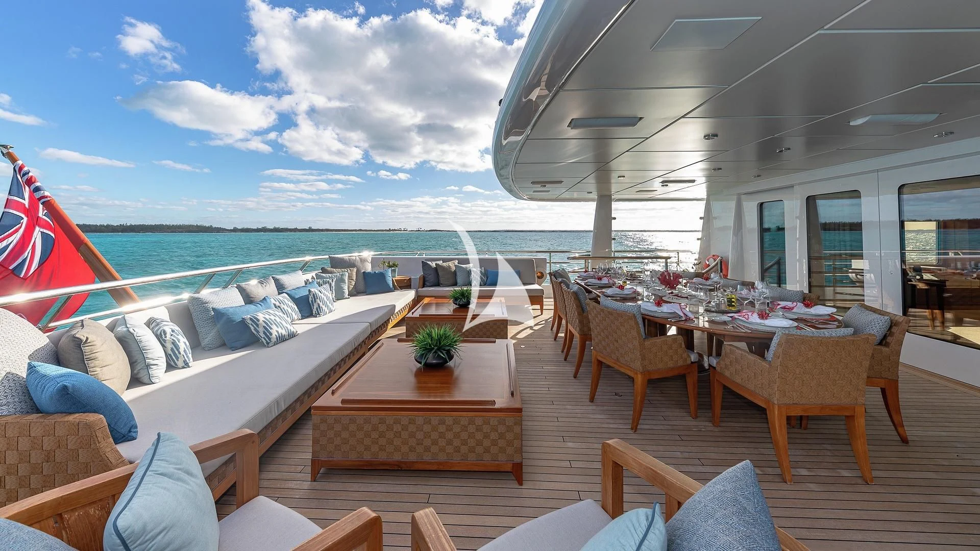a room with a table chairs and a view of the ocean aboard LIND Yacht for Charter
