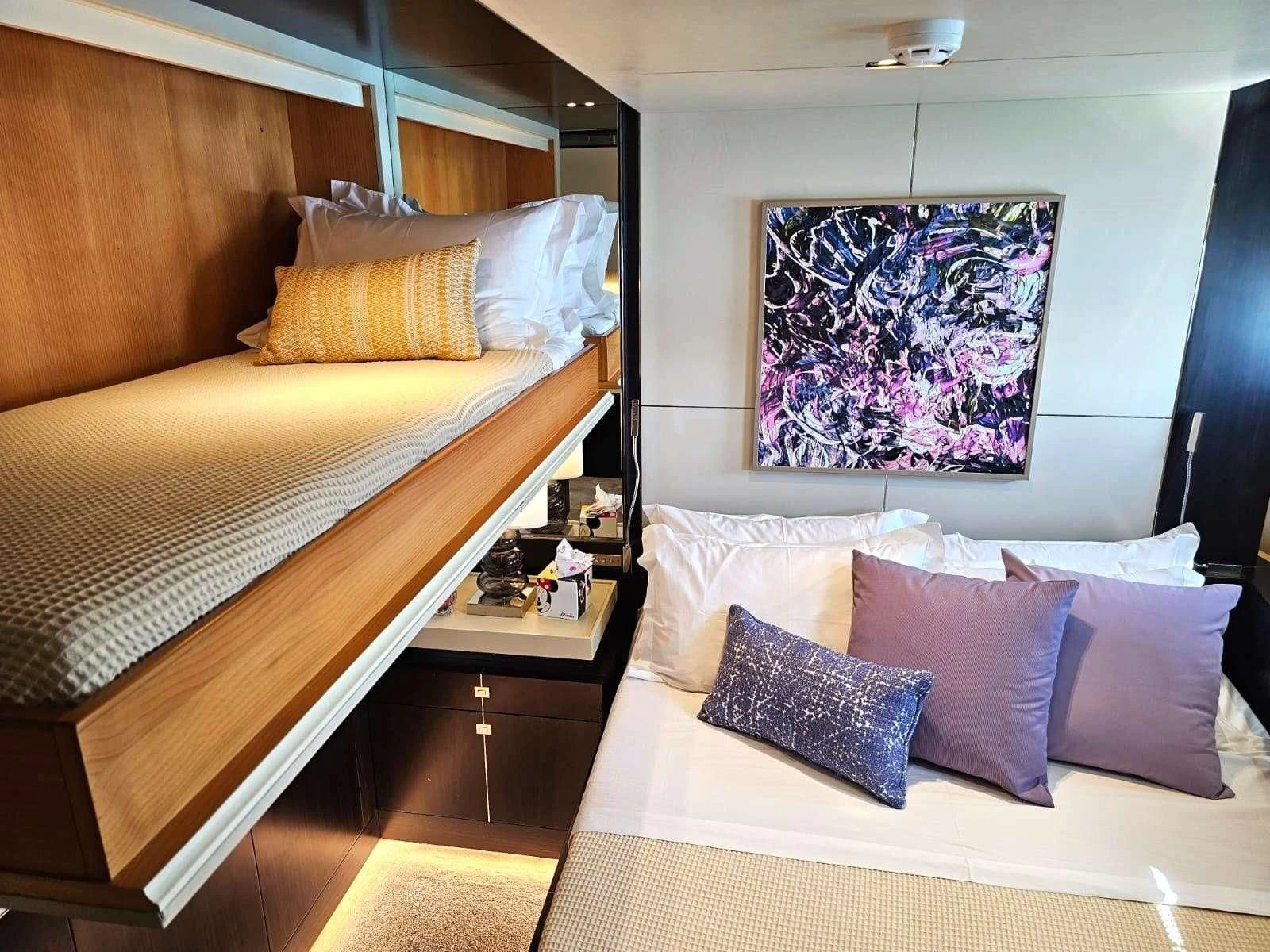 a room with a bed and a painting on the wall aboard MAC Yacht for Sale