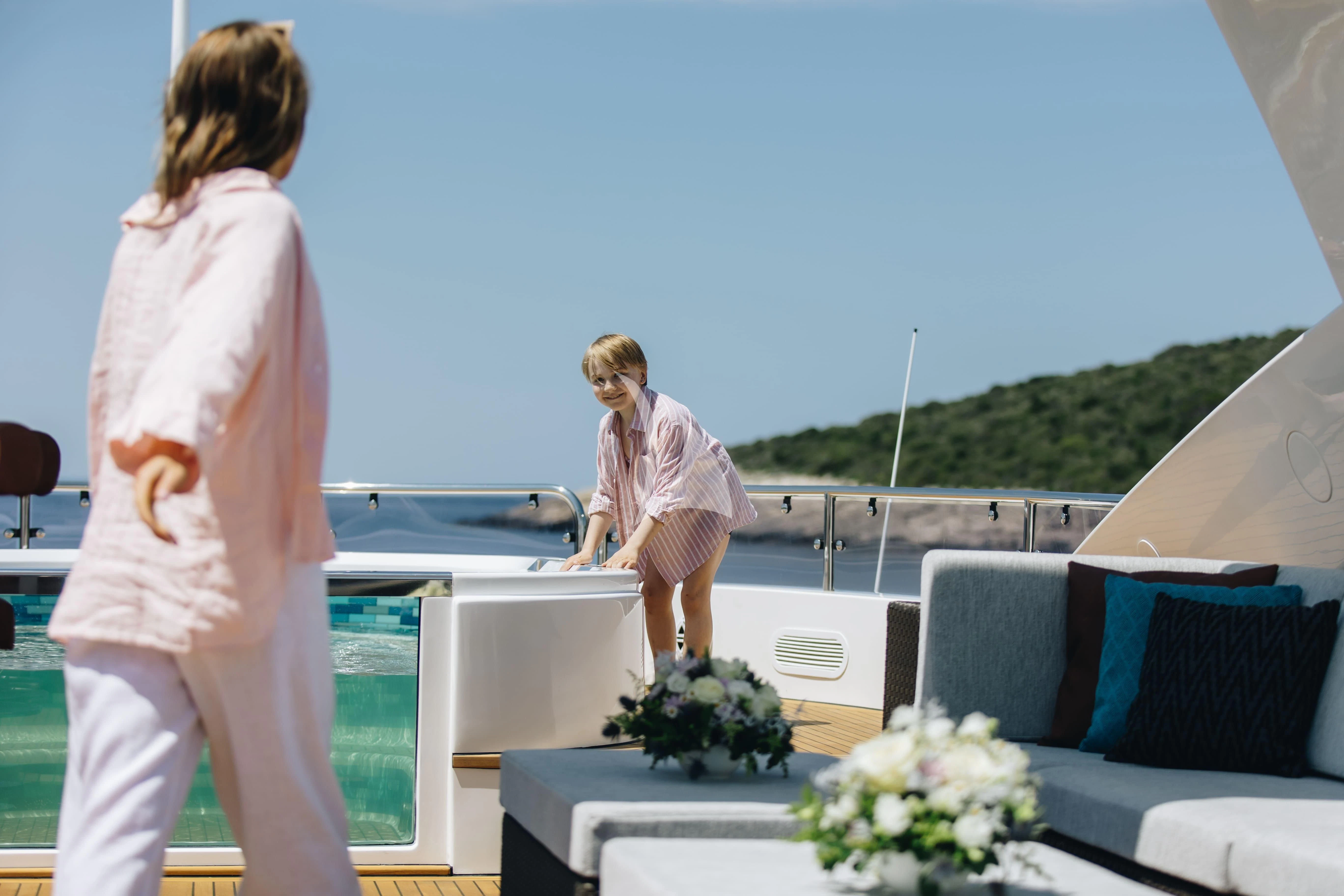 a couple of women standing on a balcony overlooking a body of water aboard KATARIINA I Yacht for Sale