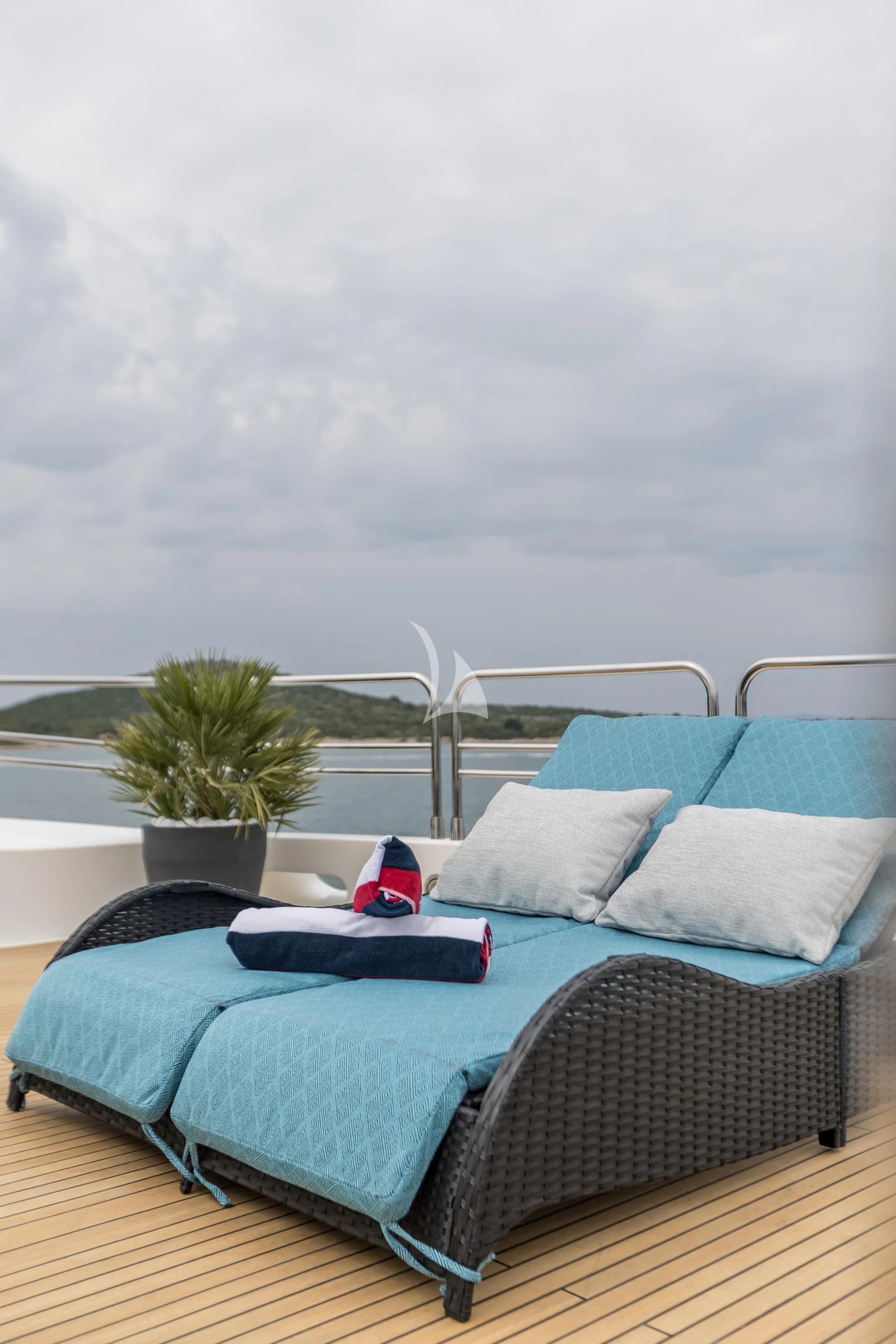a bed with a blue blanket and a plant on top of it aboard KATARIINA I Yacht for Sale