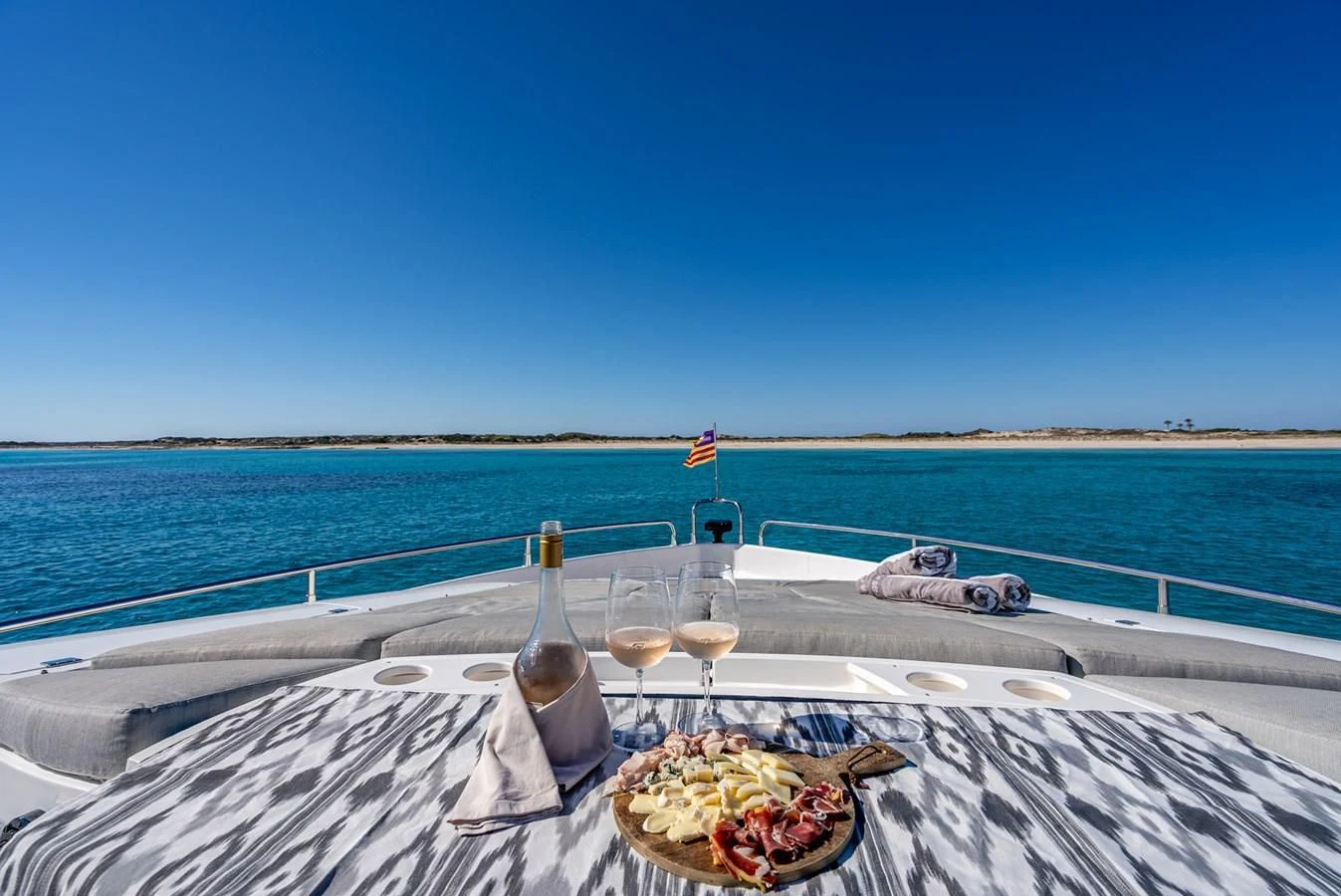 a table with food and glasses on it by a body of water aboard MOZZ II Yacht for Sale