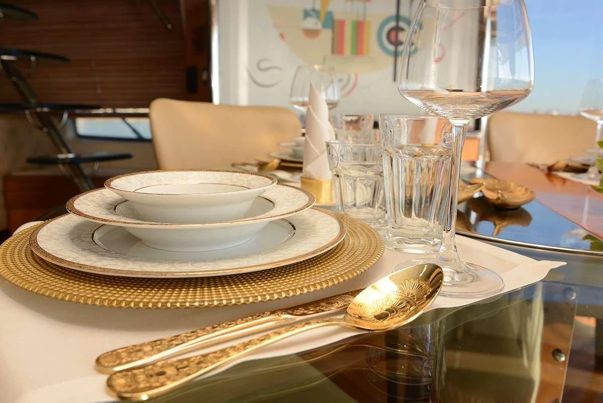 a table with plates and glasses aboard OBSIDIAN Yacht for Sale