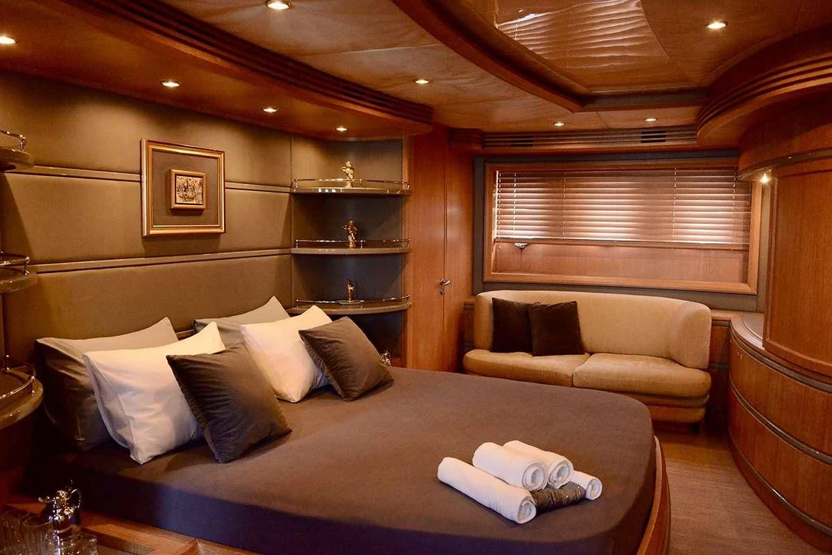 a bed with a couch and a coffee table in a room aboard OBSIDIAN Yacht for Sale