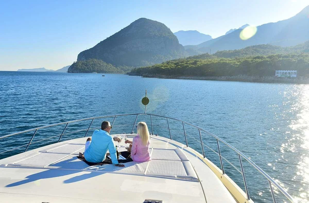 a man and woman sitting on a boat in the water aboard OBSIDIAN Yacht for Sale