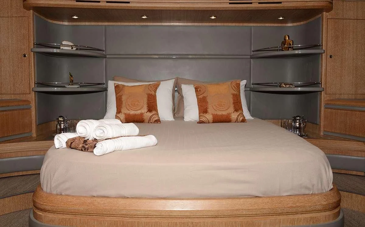a bed with a white sheet and pillows on it aboard OBSIDIAN Yacht for Sale