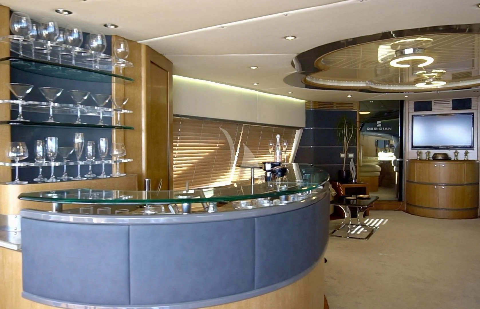 a bar with a bar and a television on the wall aboard OBSIDIAN Yacht for Sale