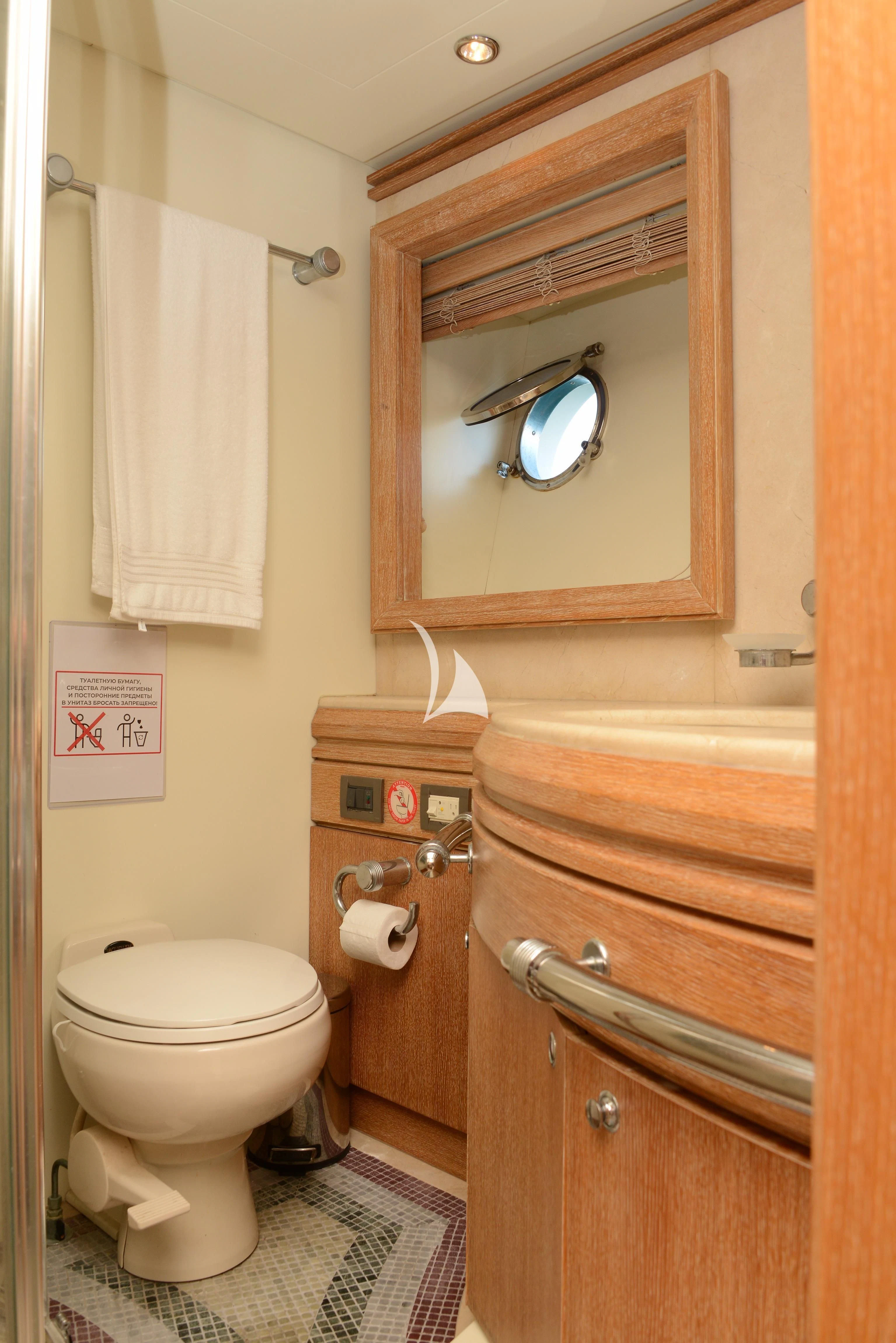 a bathroom with a toilet and a mirror aboard OBSIDIAN Yacht for Sale