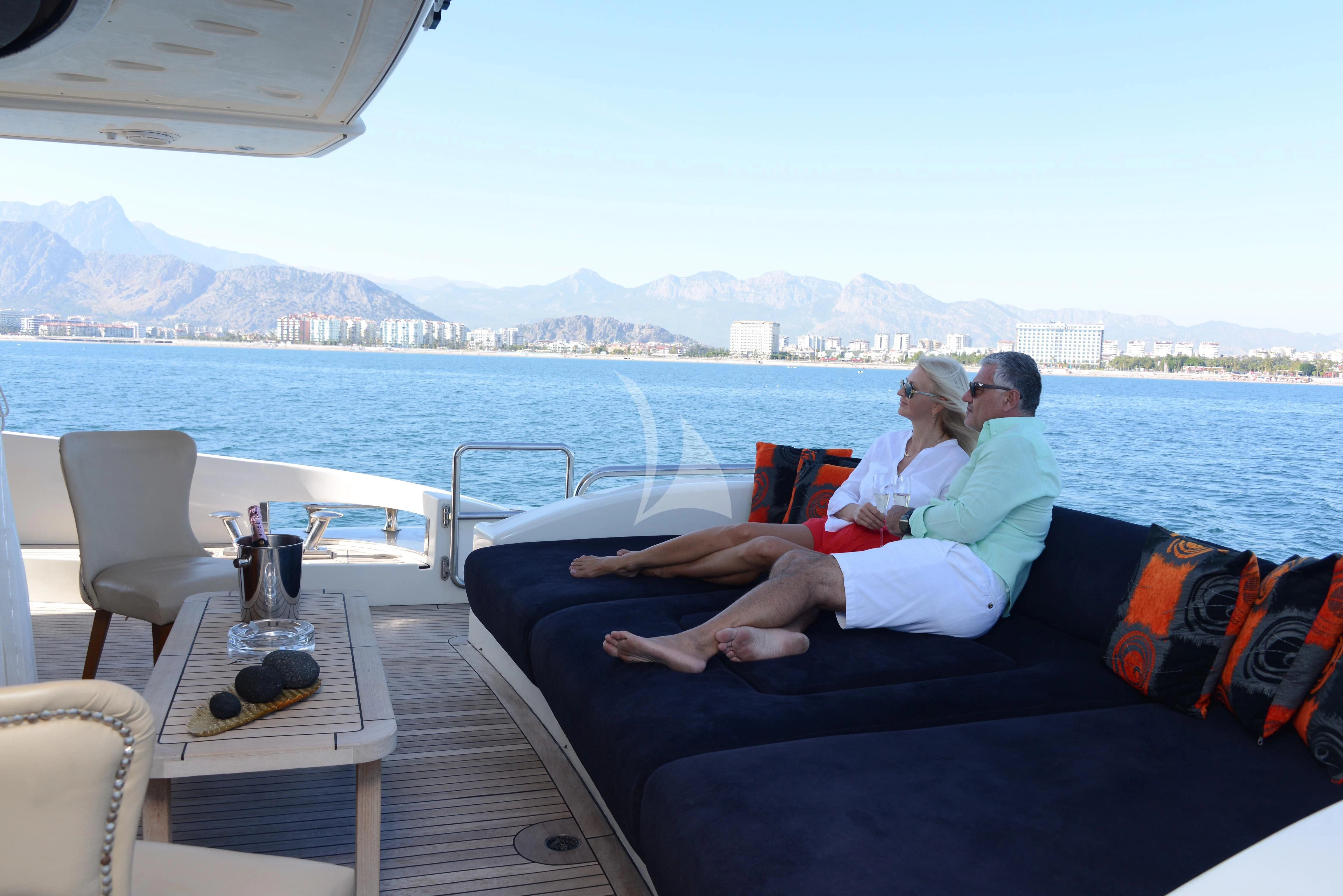 a man and woman sitting on a couch on a boat aboard OBSIDIAN Yacht for Sale