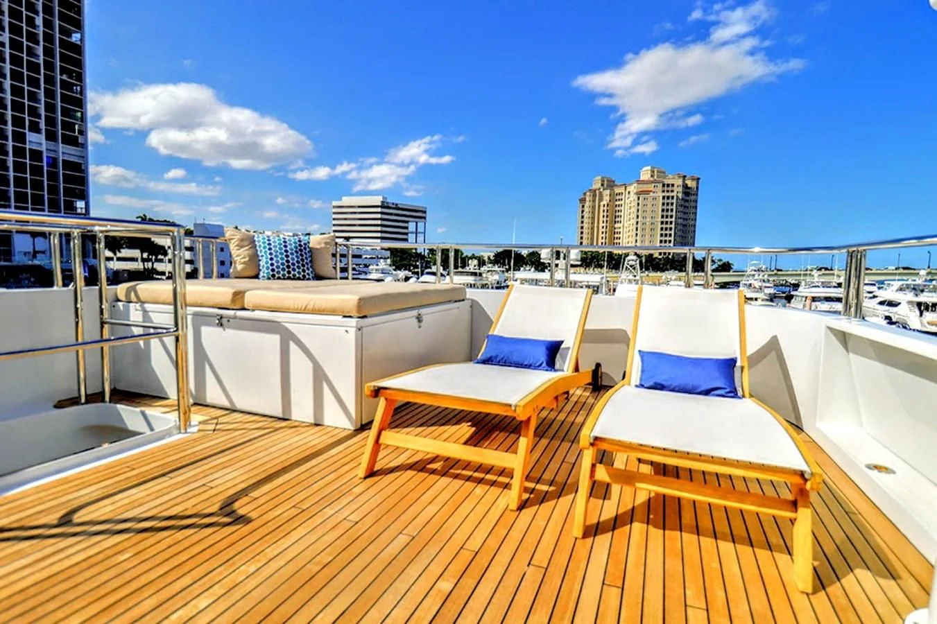 a deck with chairs and a view of the city aboard JUST ENOUGH Yacht for Charter