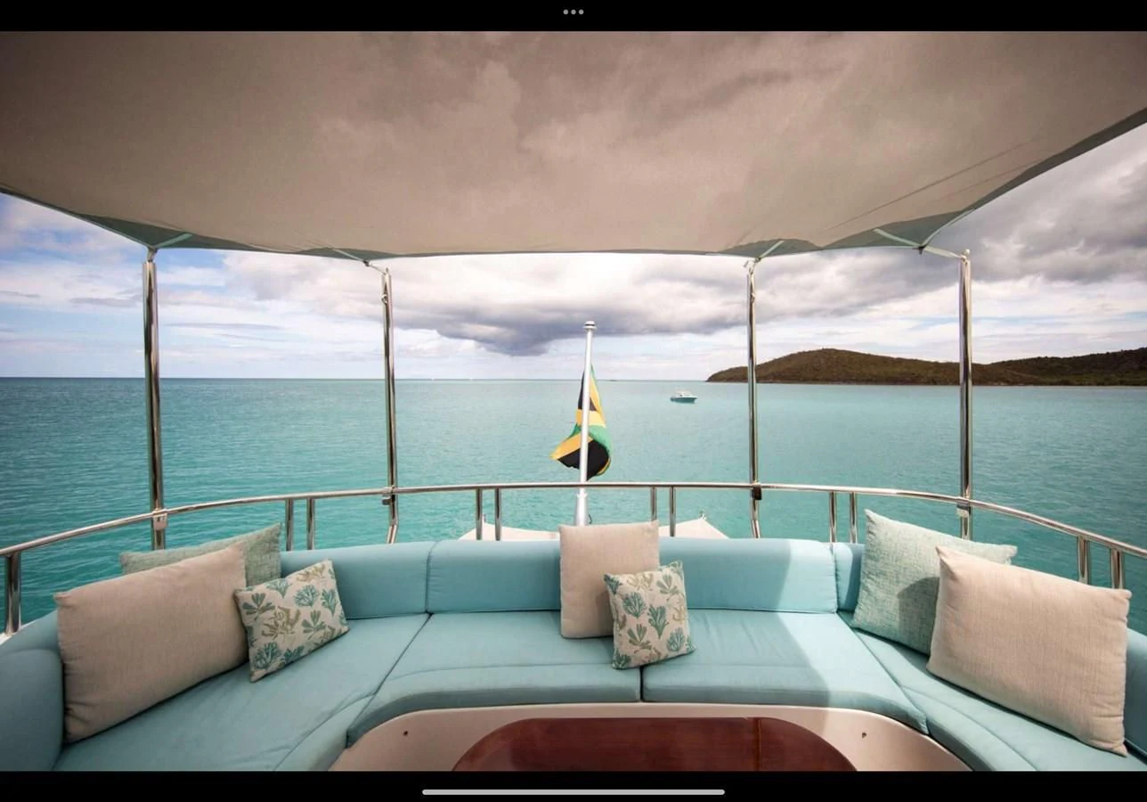 a couch with pillows and a flag on it by the ocean aboard JUST ENOUGH Yacht for Charter