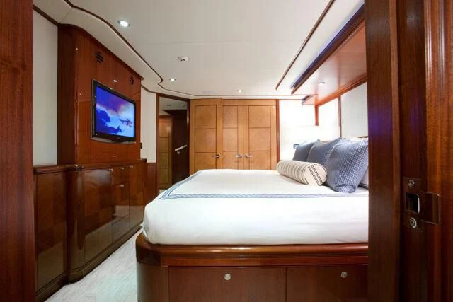 a bed with a television on the wall aboard JUST ENOUGH Yacht for Charter