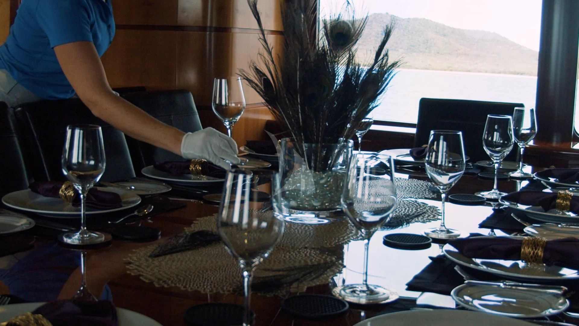 a table with wine glasses and plates aboard JUST ENOUGH Yacht for Charter