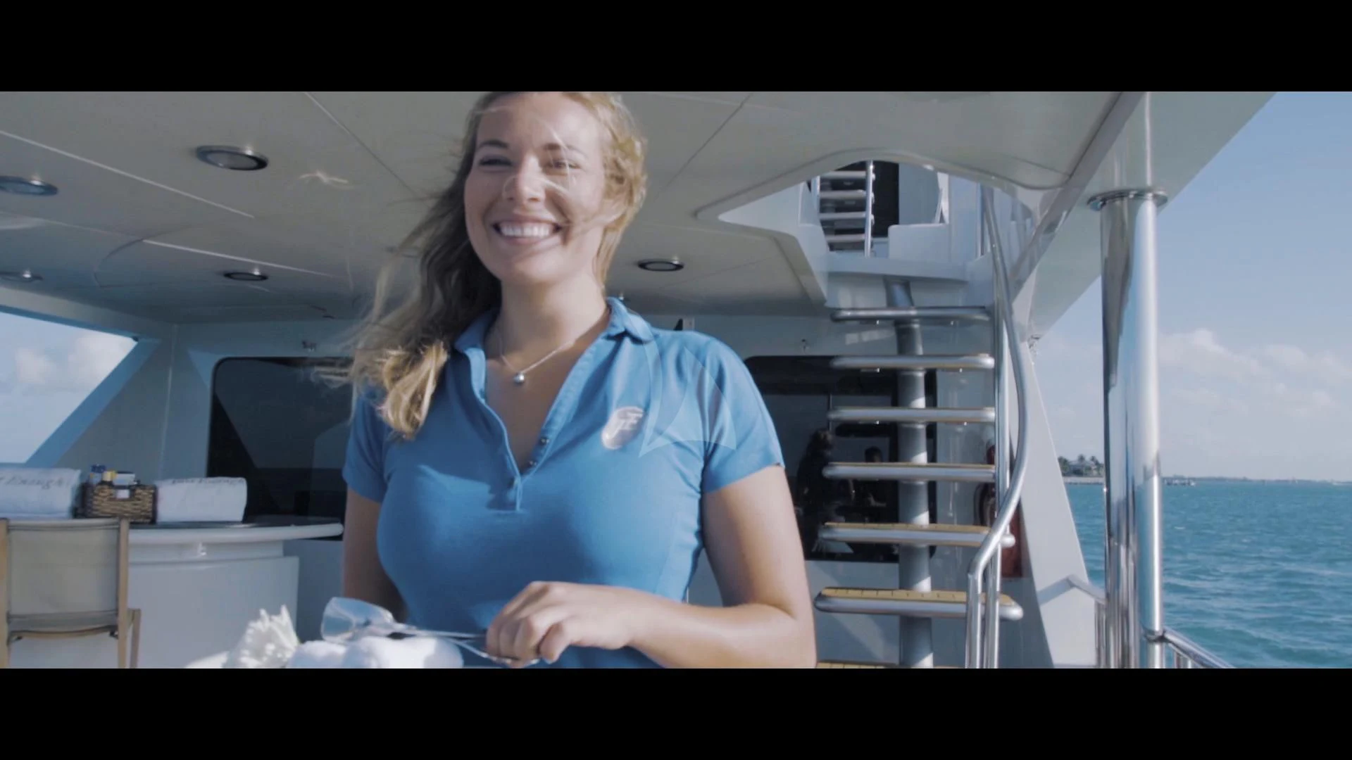 a woman in a blue shirt aboard JUST ENOUGH Yacht for Charter