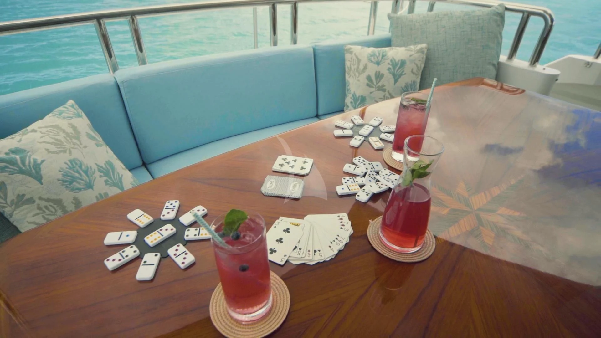 a table with a glass of liquid and a tray of cards on it aboard JUST ENOUGH Yacht for Charter