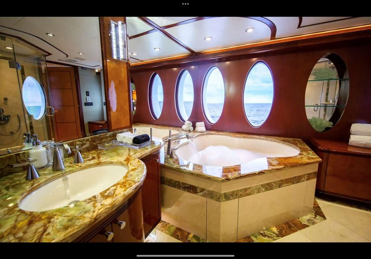 a bathroom with a tub sink and a large mirror aboard JUST ENOUGH Yacht for Charter