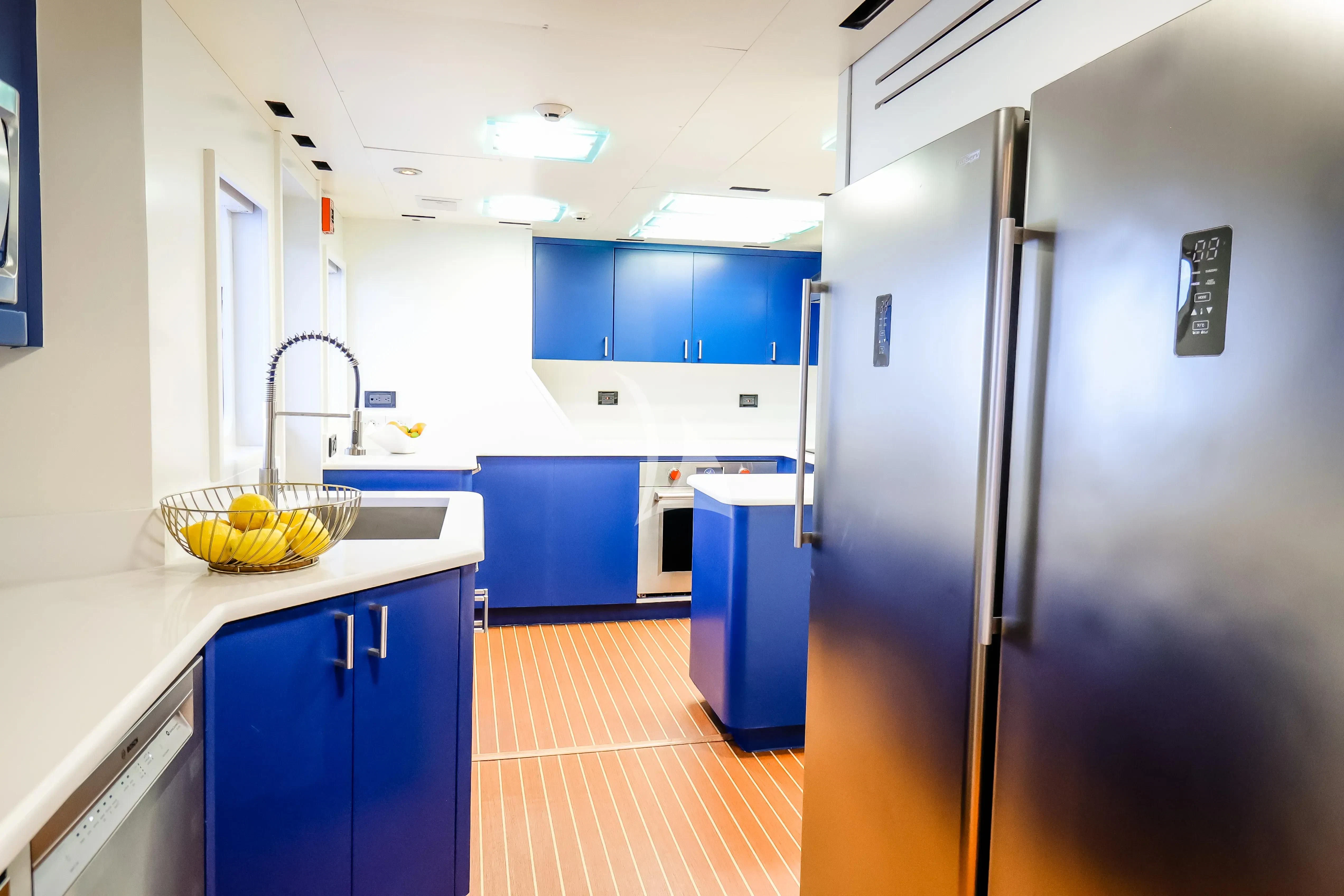 a kitchen with blue cabinets aboard JUST ENOUGH Yacht for Charter
