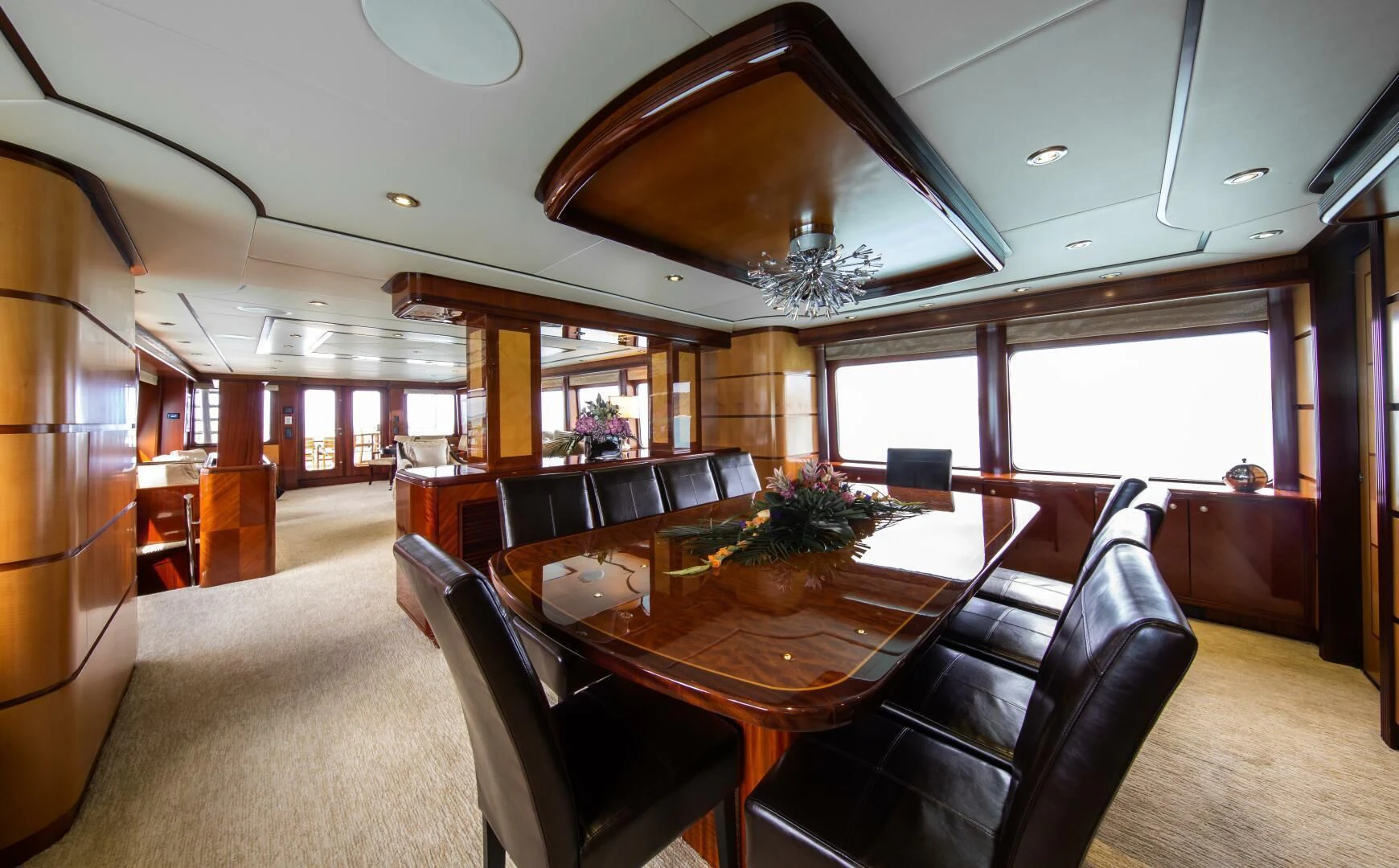 a dining room with a large chandelier aboard JUST ENOUGH Yacht for Charter