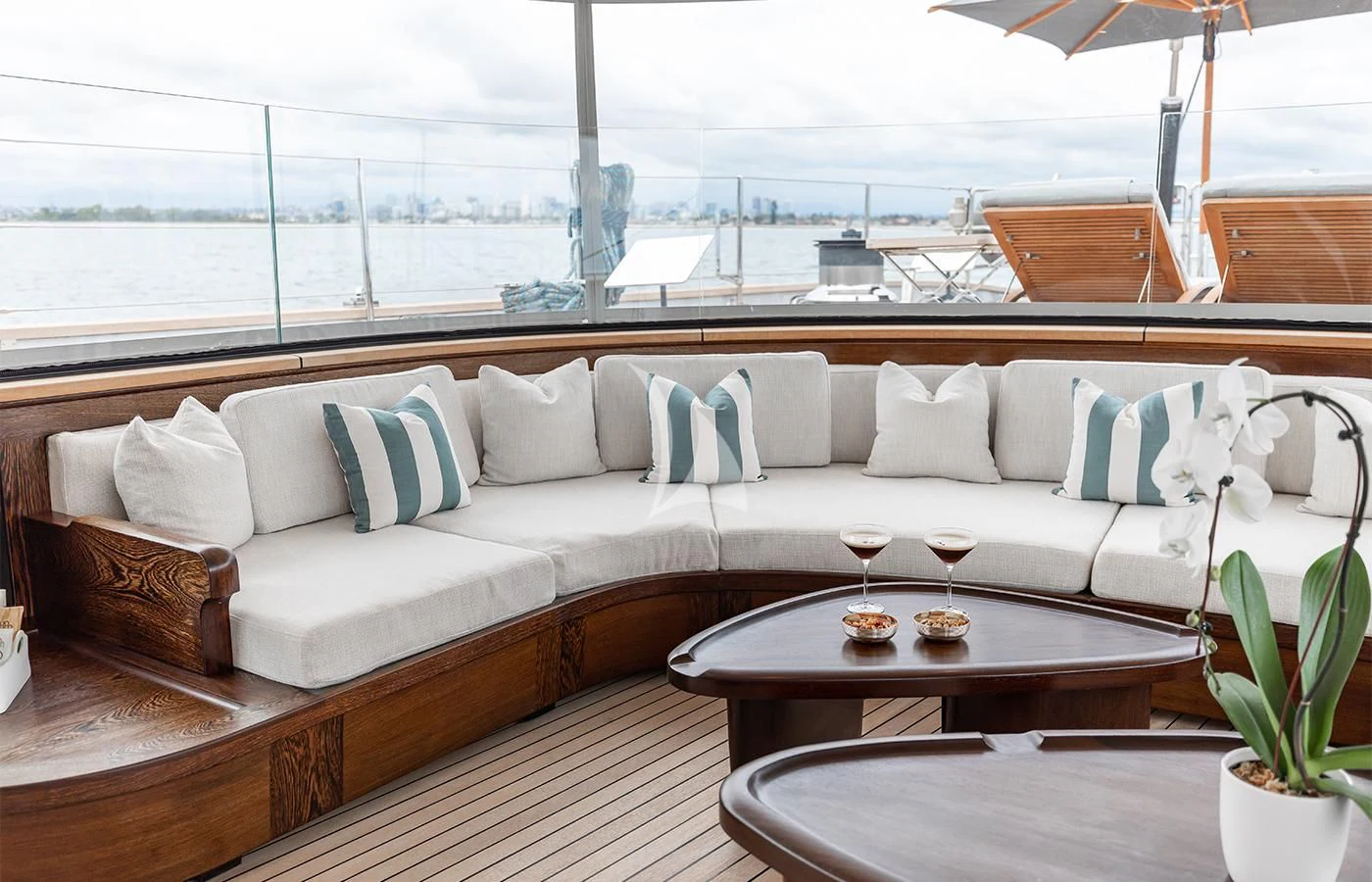 a couch with a table and wine glasses on it aboard PERSEUS^3 Yacht for Sale