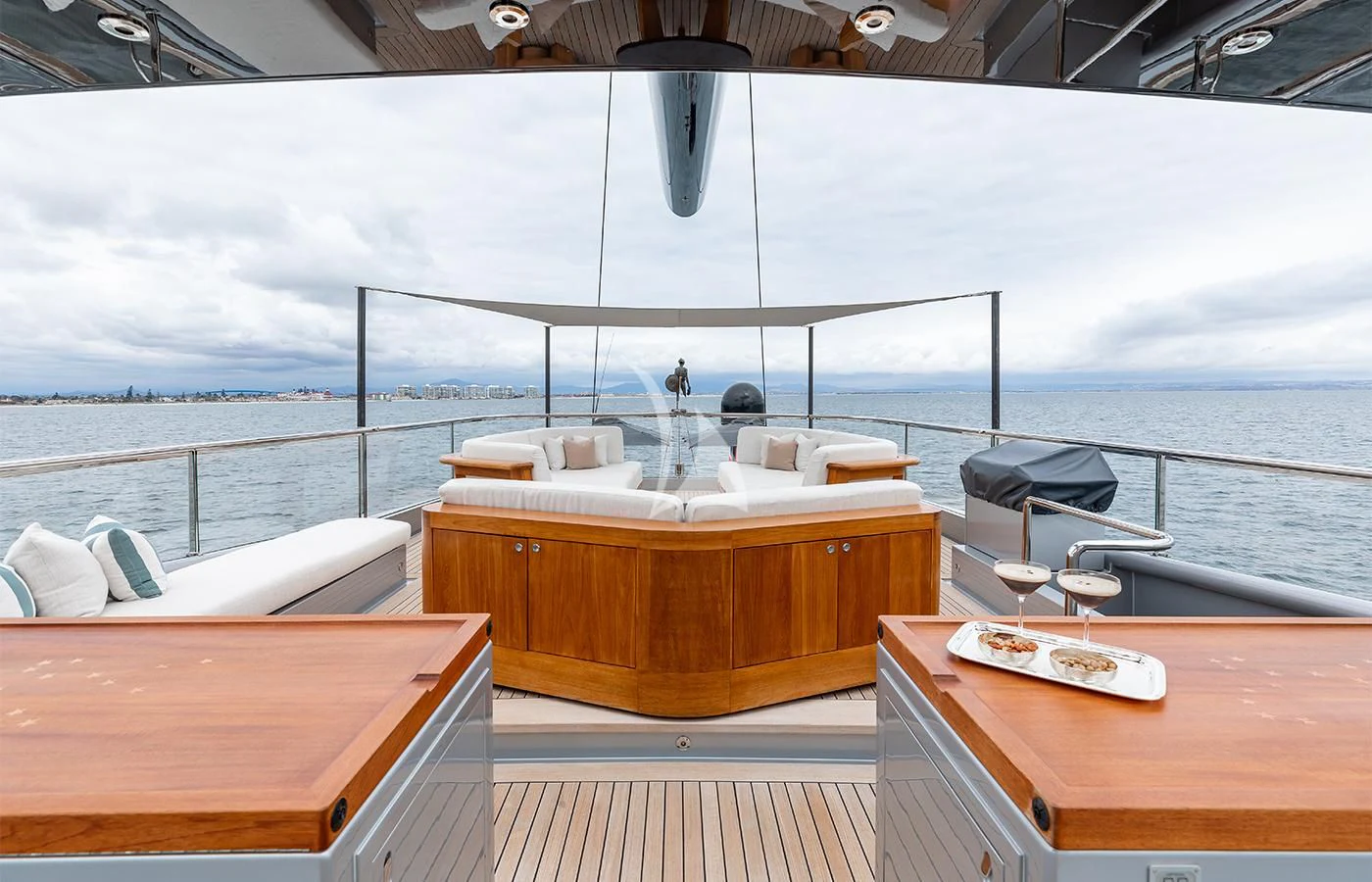 a table with a glass of wine on it next to a large body of water aboard PERSEUS^3 Yacht for Sale