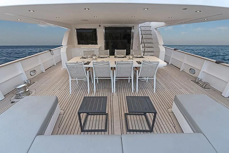 a room with a table chairs and a large pool aboard PROJECT STEEL Yacht for Sale
