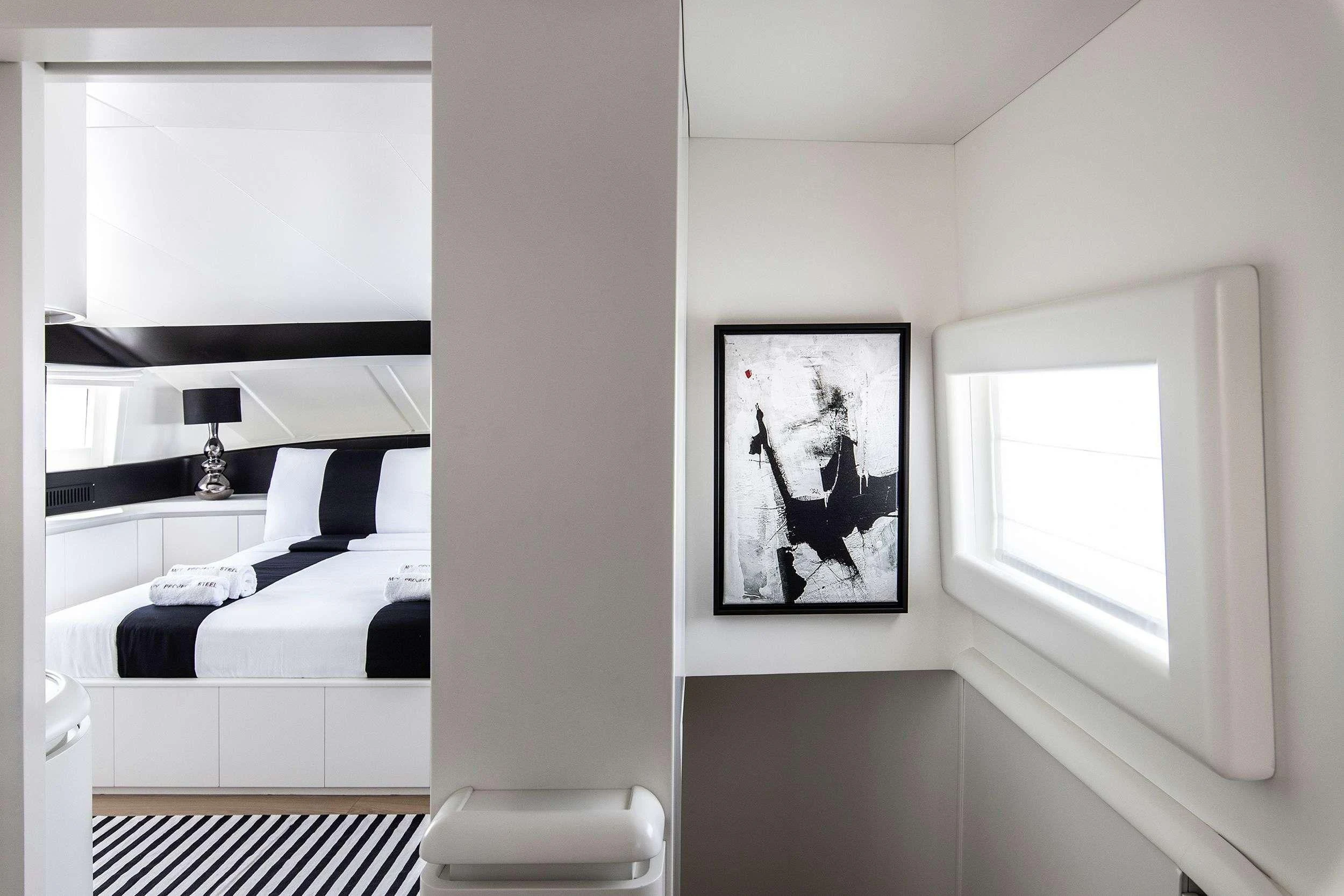 a room with a bed and a picture on the wall aboard PROJECT STEEL Yacht for Sale