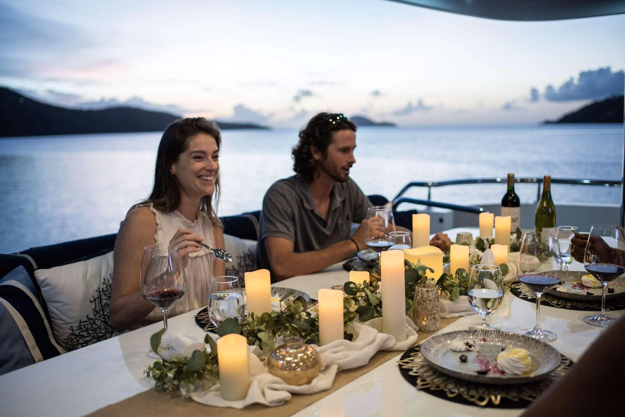 a group of people sitting at a table with food and drinks on it aboard OUTTA TOUCH Yacht for Sale