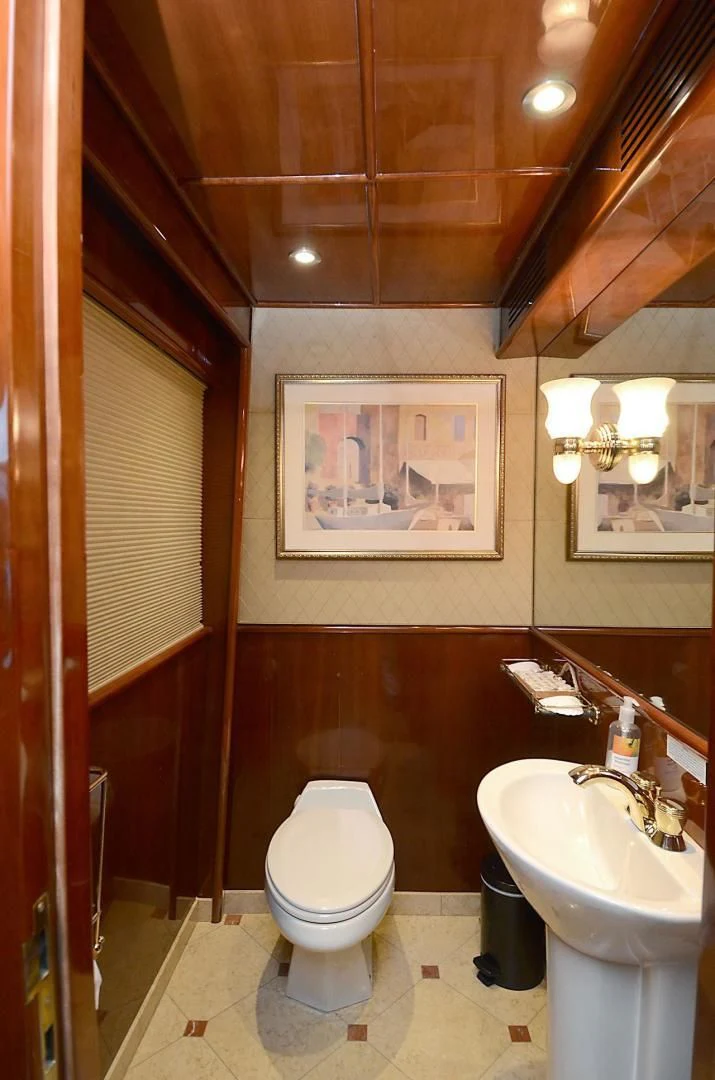 a bathroom with a toilet sink and a painting on the wall aboard OUTTA TOUCH Yacht for Sale