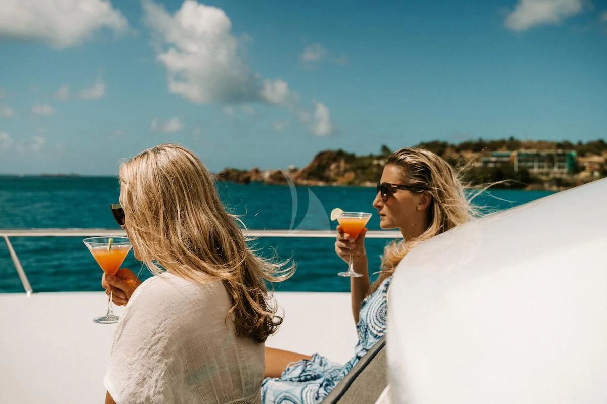 a couple of women sitting on a boat holding drinks aboard OUTTA TOUCH Yacht for Sale