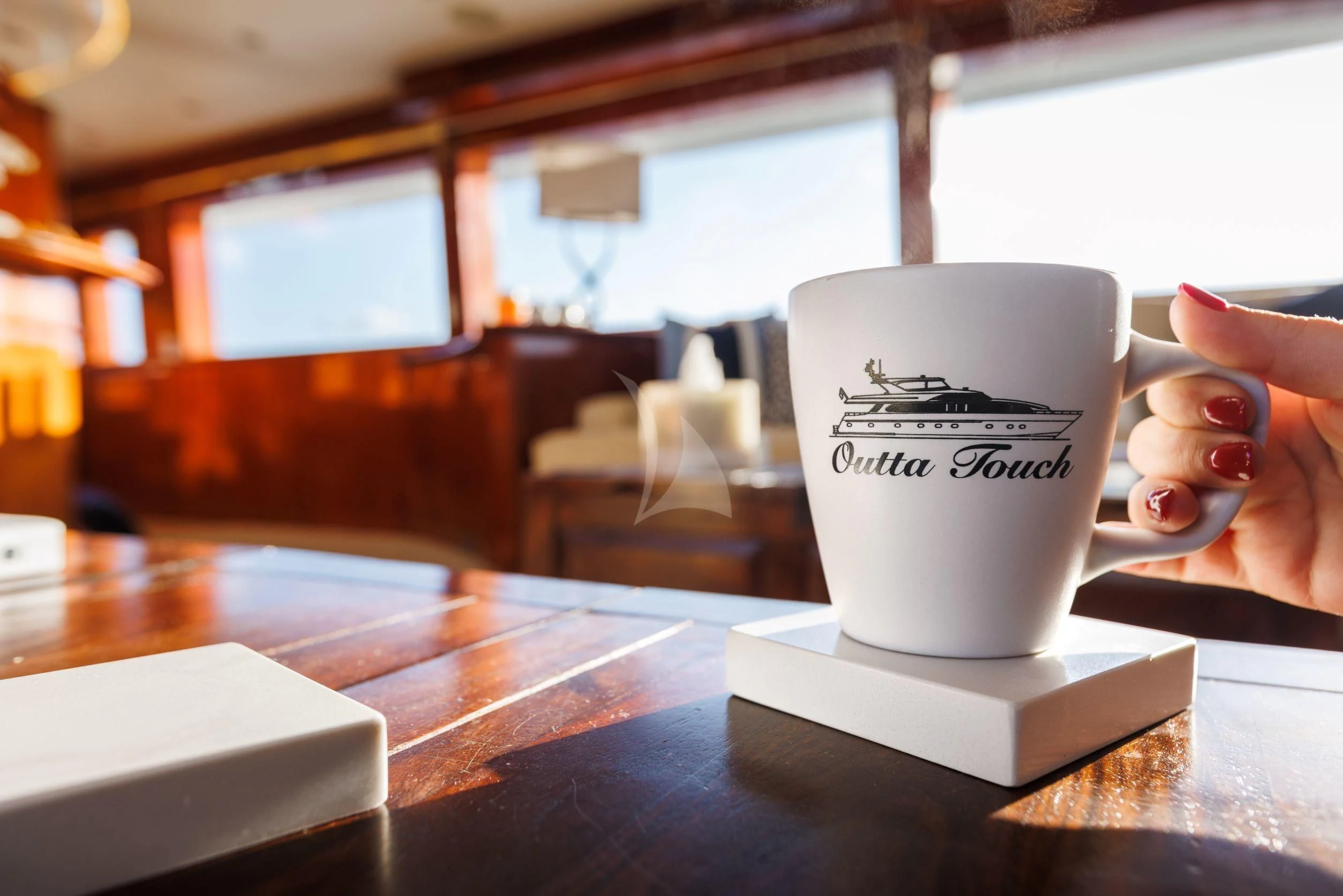 a hand holding a cup of coffee aboard OUTTA TOUCH Yacht for Sale