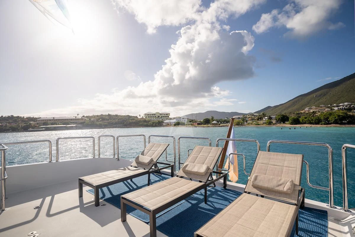 a deck with chairs and a table on it aboard OUTTA TOUCH Yacht for Sale