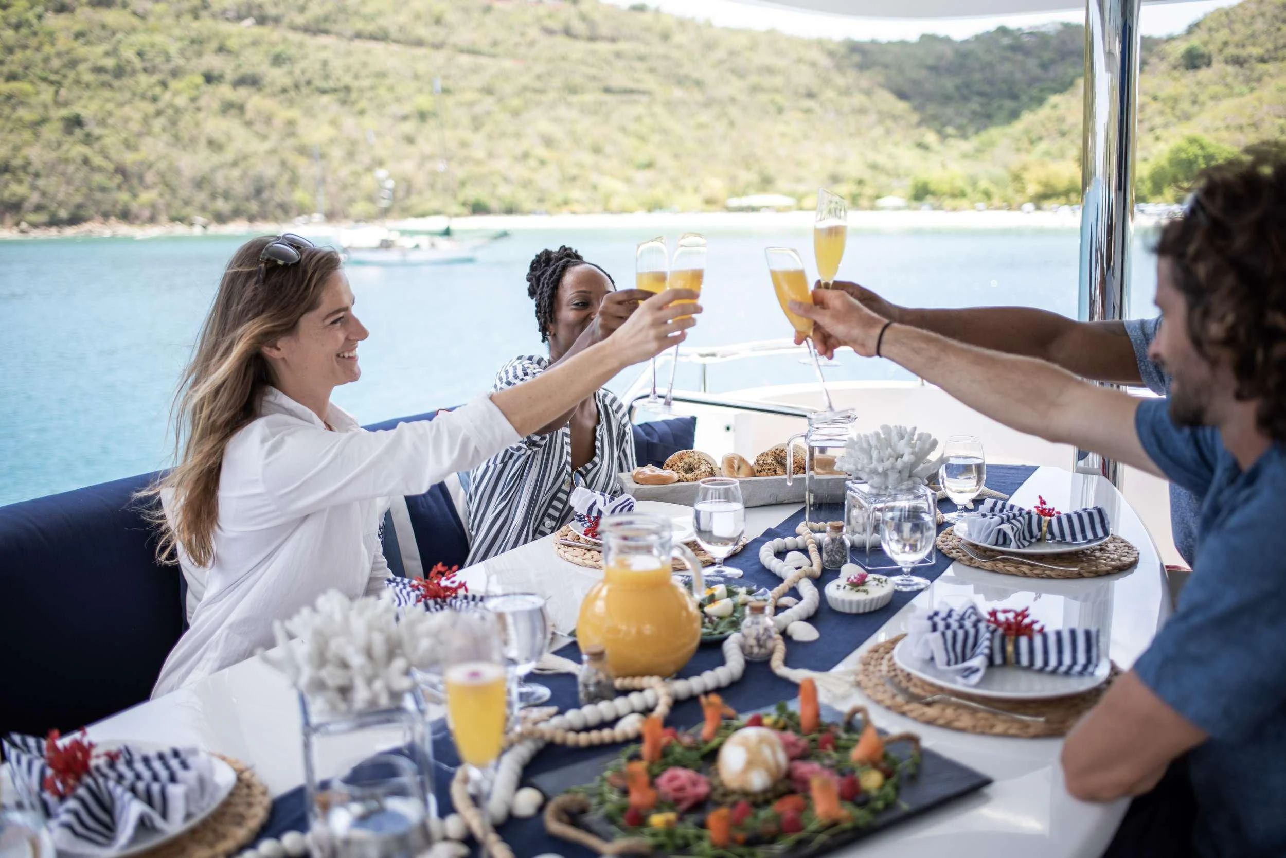 a group of people sitting at a table with food and drinks aboard OUTTA TOUCH Yacht for Sale