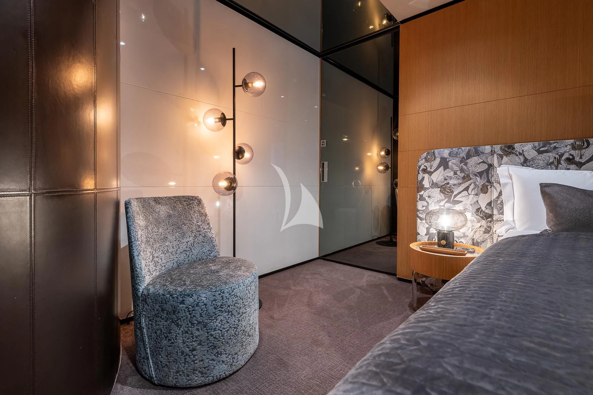 a bed and a chair in a room aboard MR. T Yacht for Charter