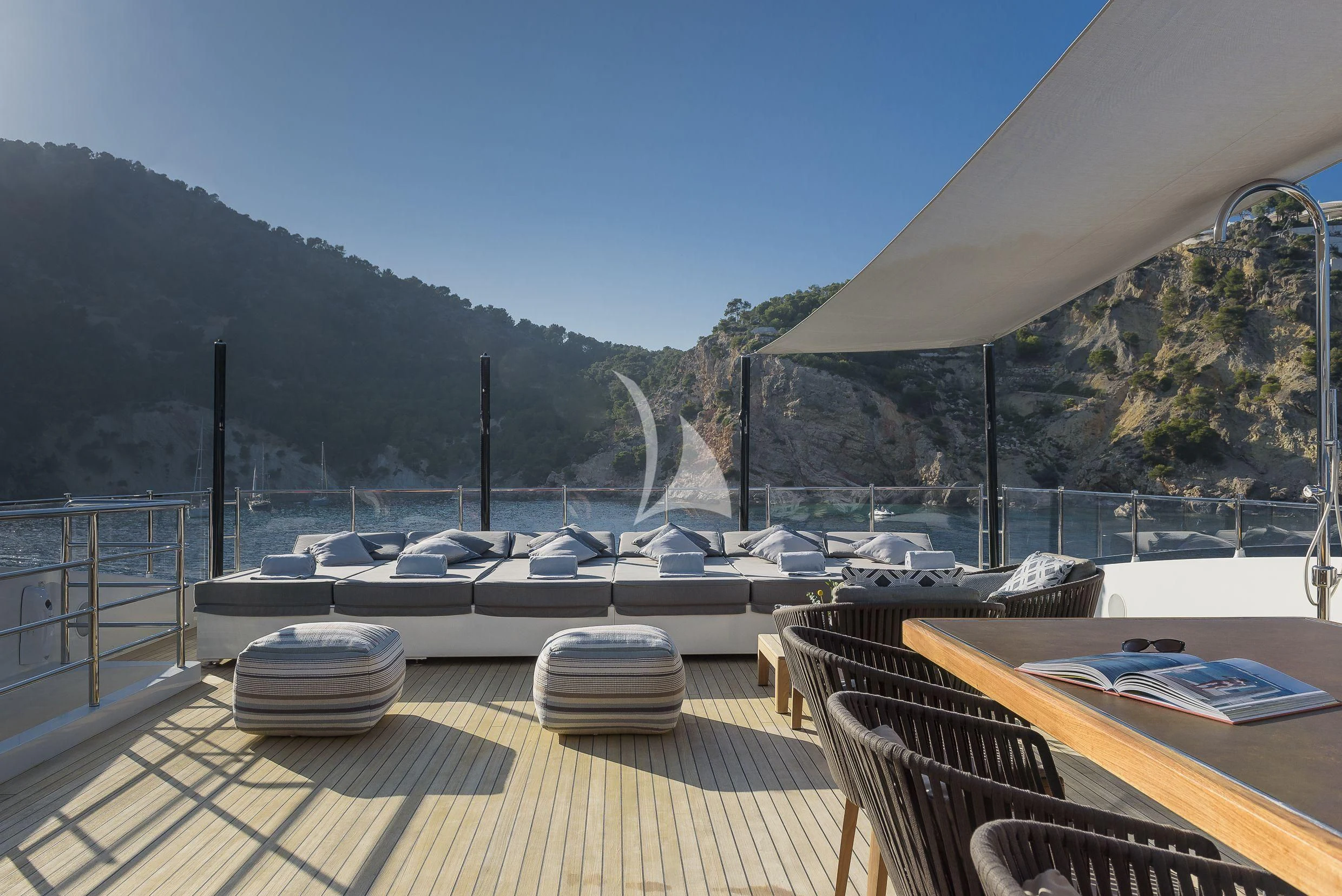 a deck with a view of a lake and mountains aboard MR. T Yacht for Charter