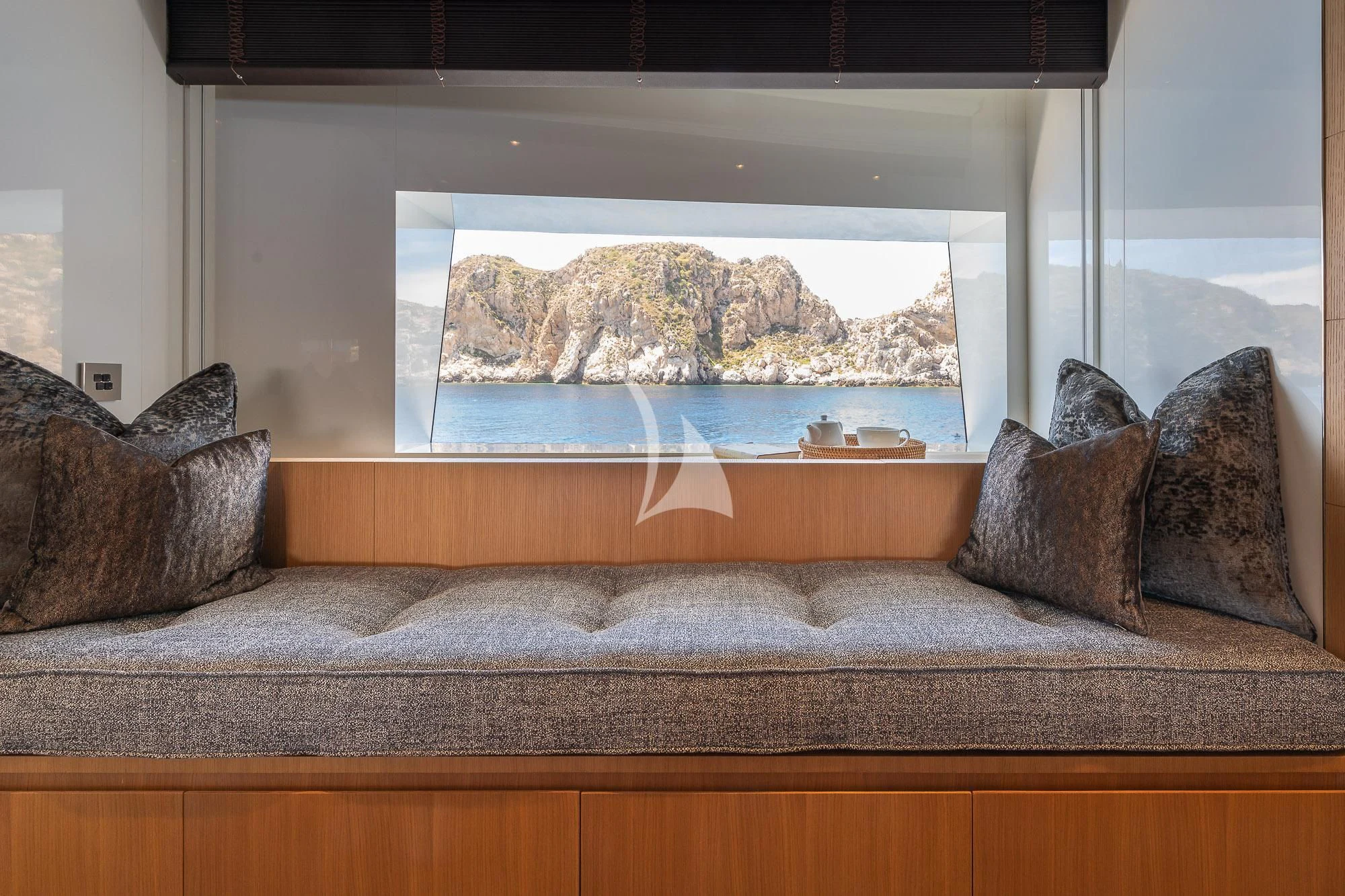 a couch with a large window aboard MR. T Yacht for Charter