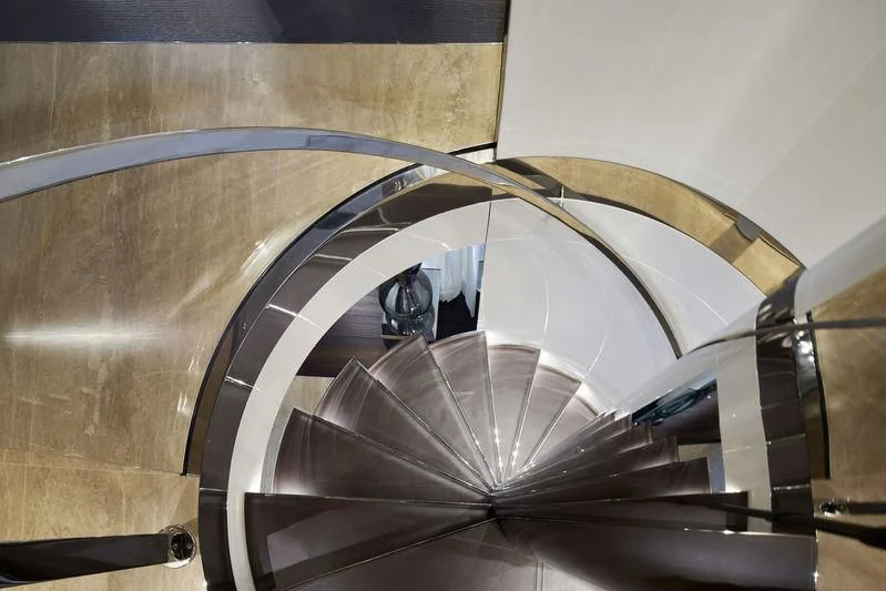 a person sitting in a spiral staircase aboard MR. T Yacht for Charter