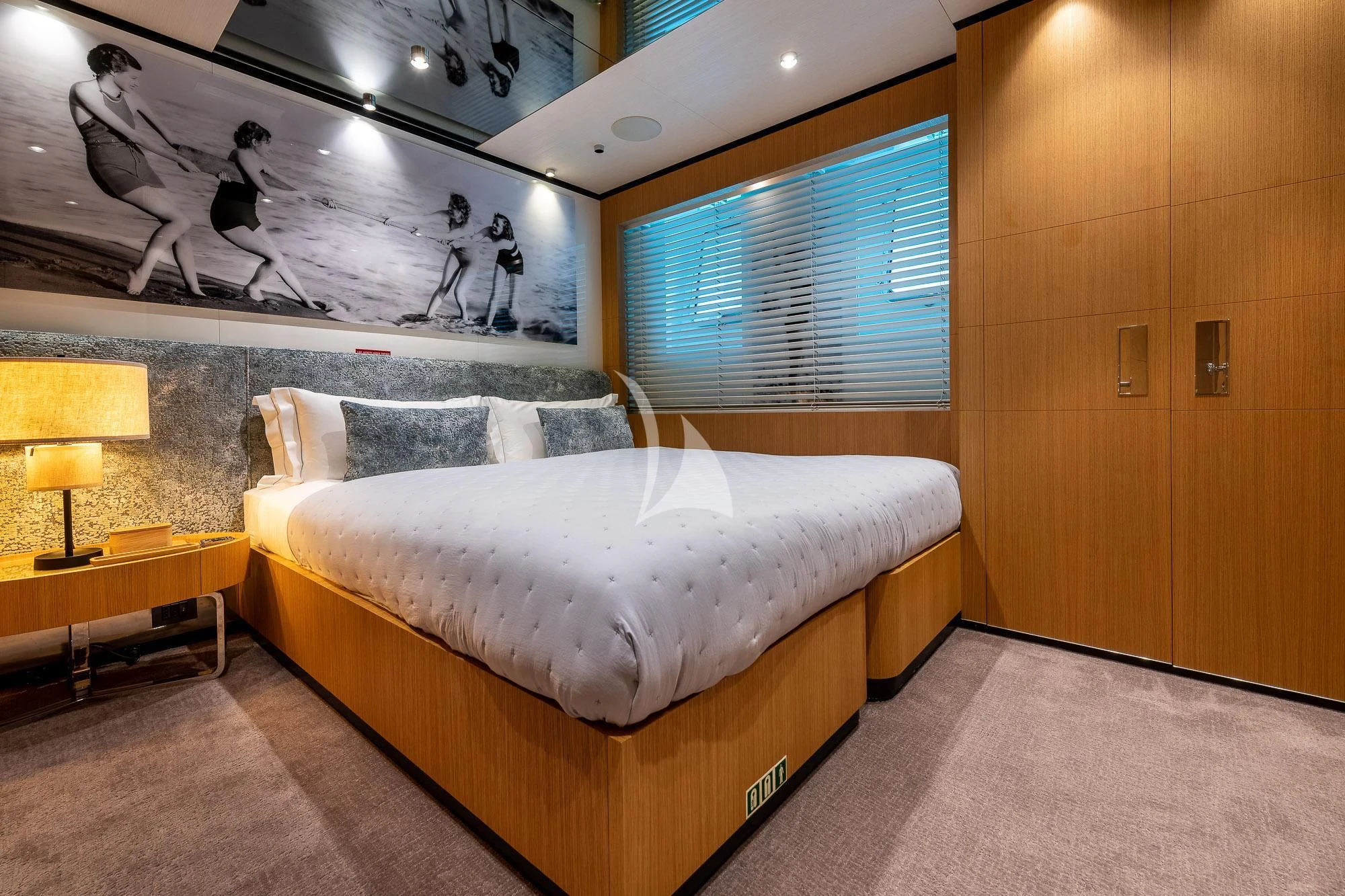 a bedroom with a bed and a lamp aboard MR. T Yacht for Charter