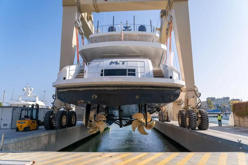 a large white boat with a large flatbed on a dock aboard MR. T Yacht for Charter