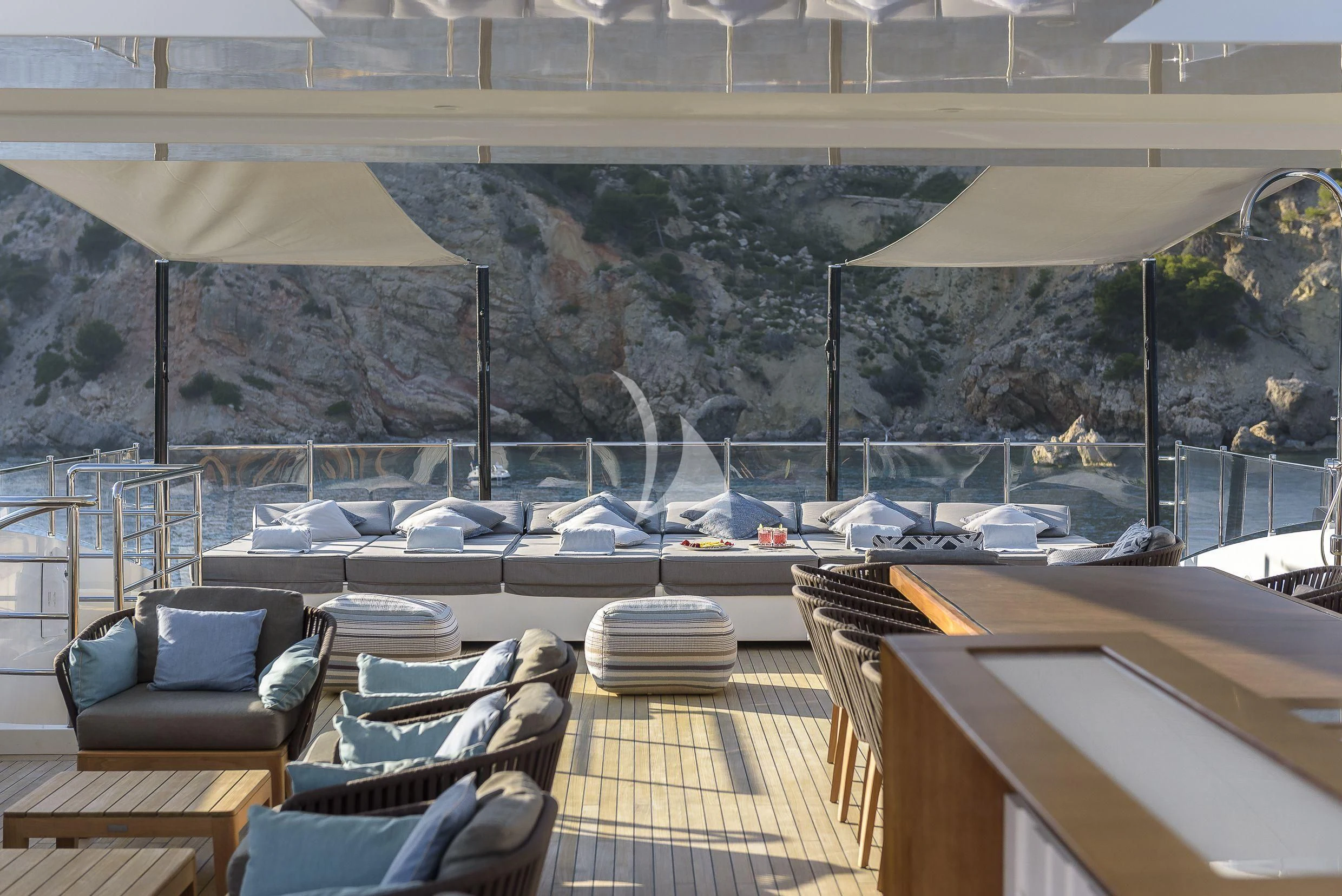a deck with a view of a city and mountains aboard MR. T Yacht for Charter