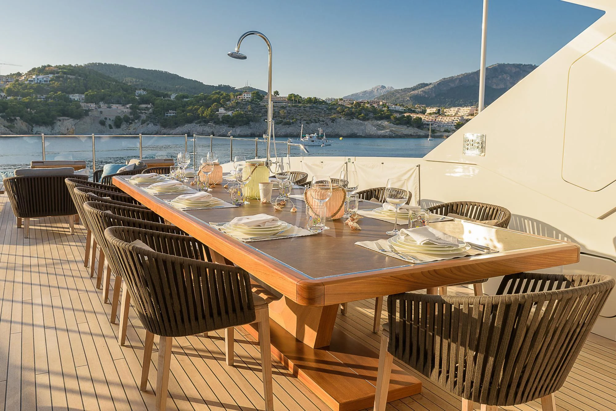 a table set for a meal on a deck overlooking a body of water aboard MR. T Yacht for Charter