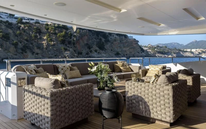 a room with couches and a table and a large body of water aboard MR. T Yacht for Charter