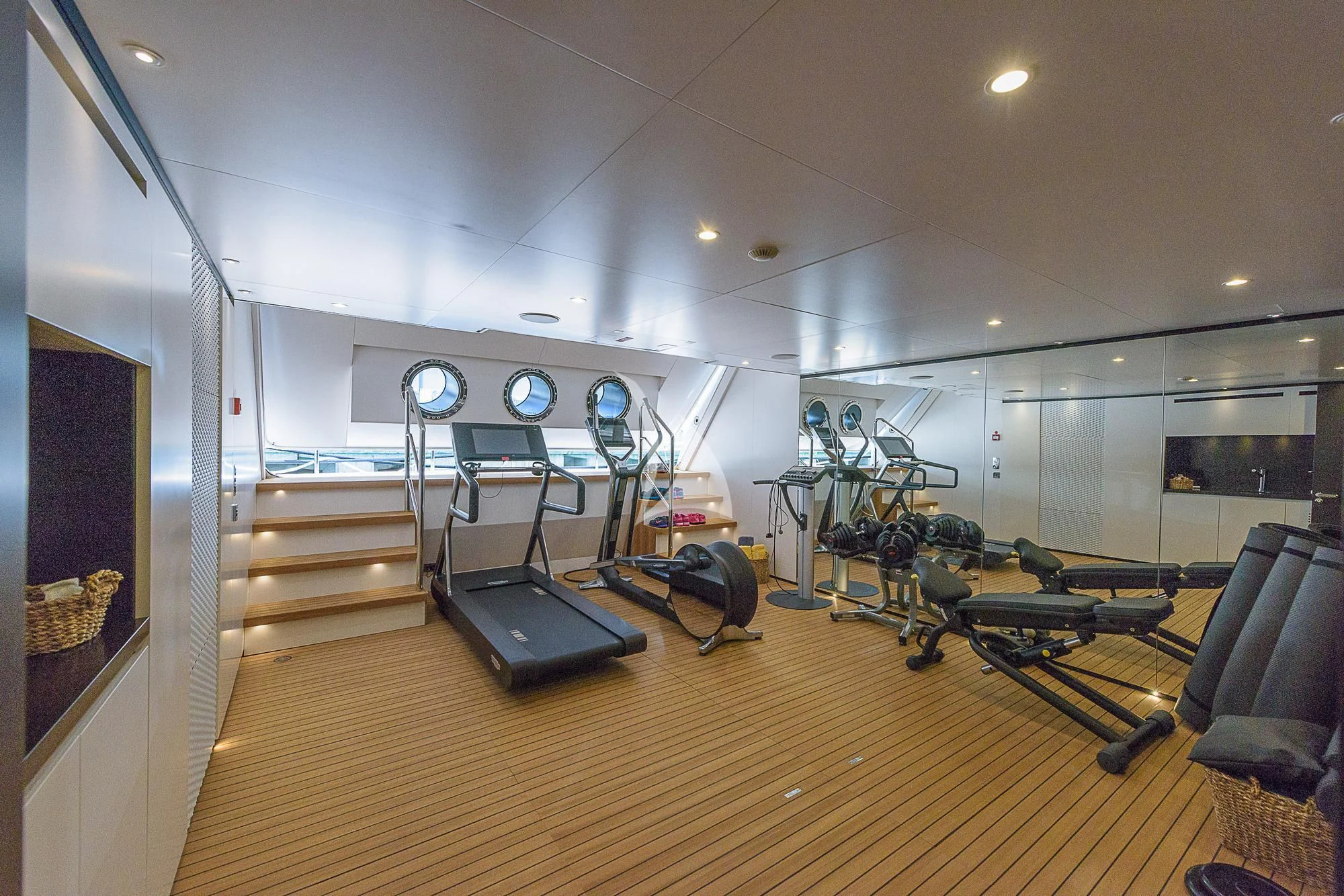 a gym with a bench and exercise equipment aboard MR. T Yacht for Charter