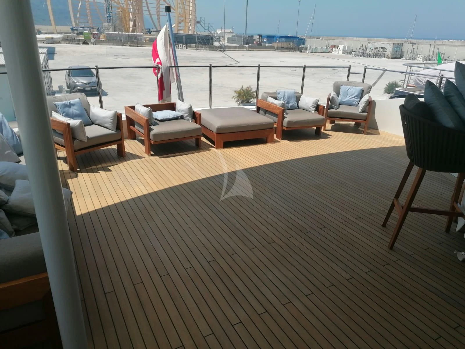 a deck with chairs and a flag aboard MR. T Yacht for Charter