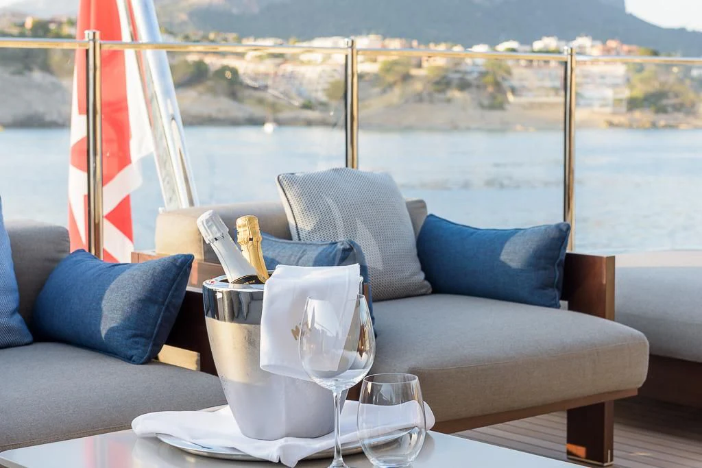 a table with a glass and a blue pillow on it aboard MR. T Yacht for Charter