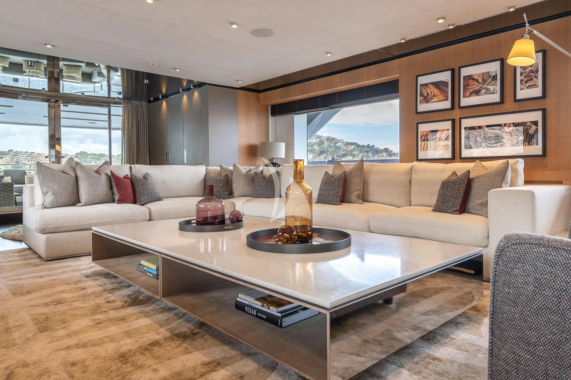 a living room with a large glass coffee table and a large window aboard MR. T Yacht for Charter