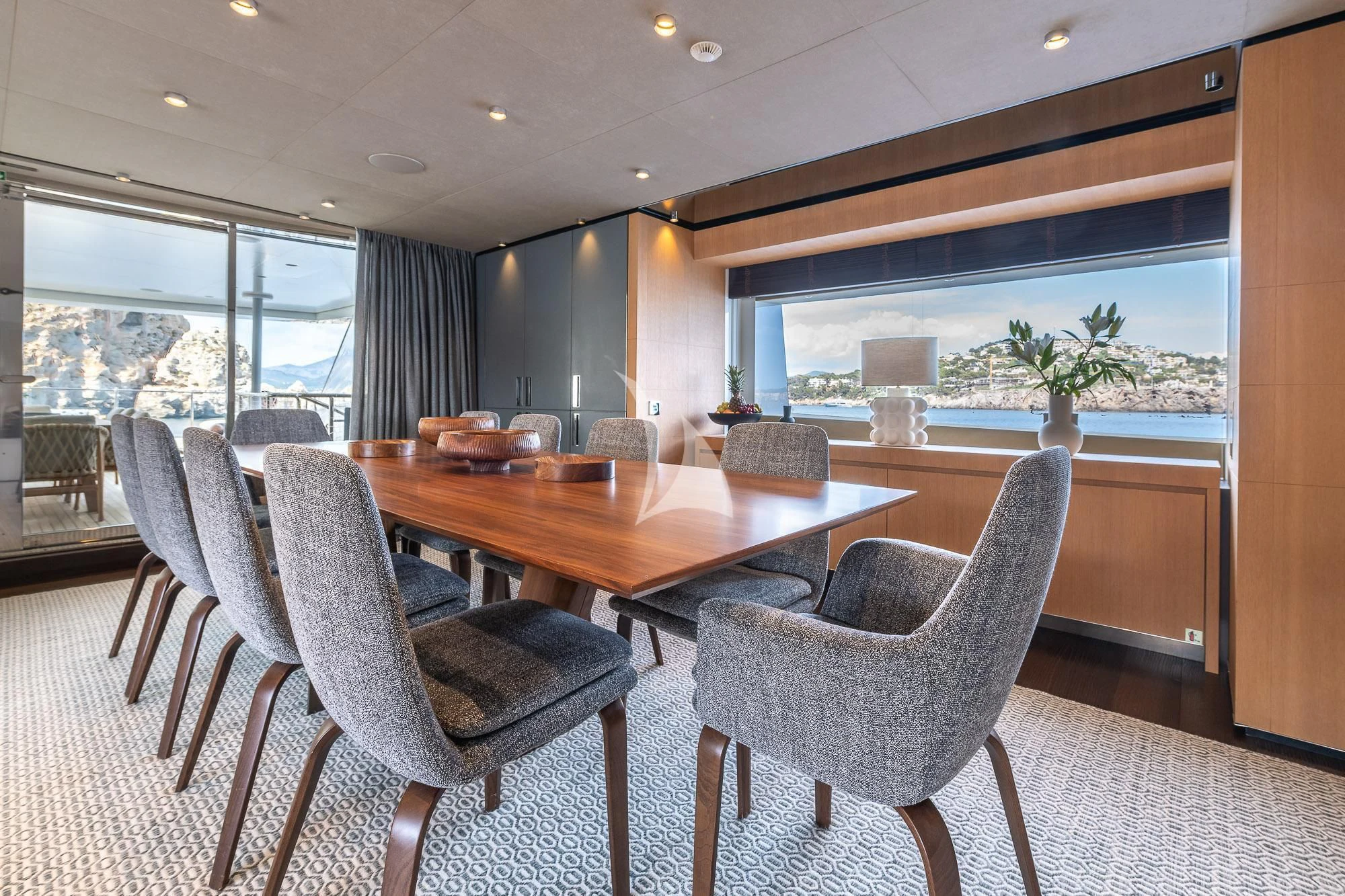 a room with a table chairs and a large window aboard MR. T Yacht for Charter