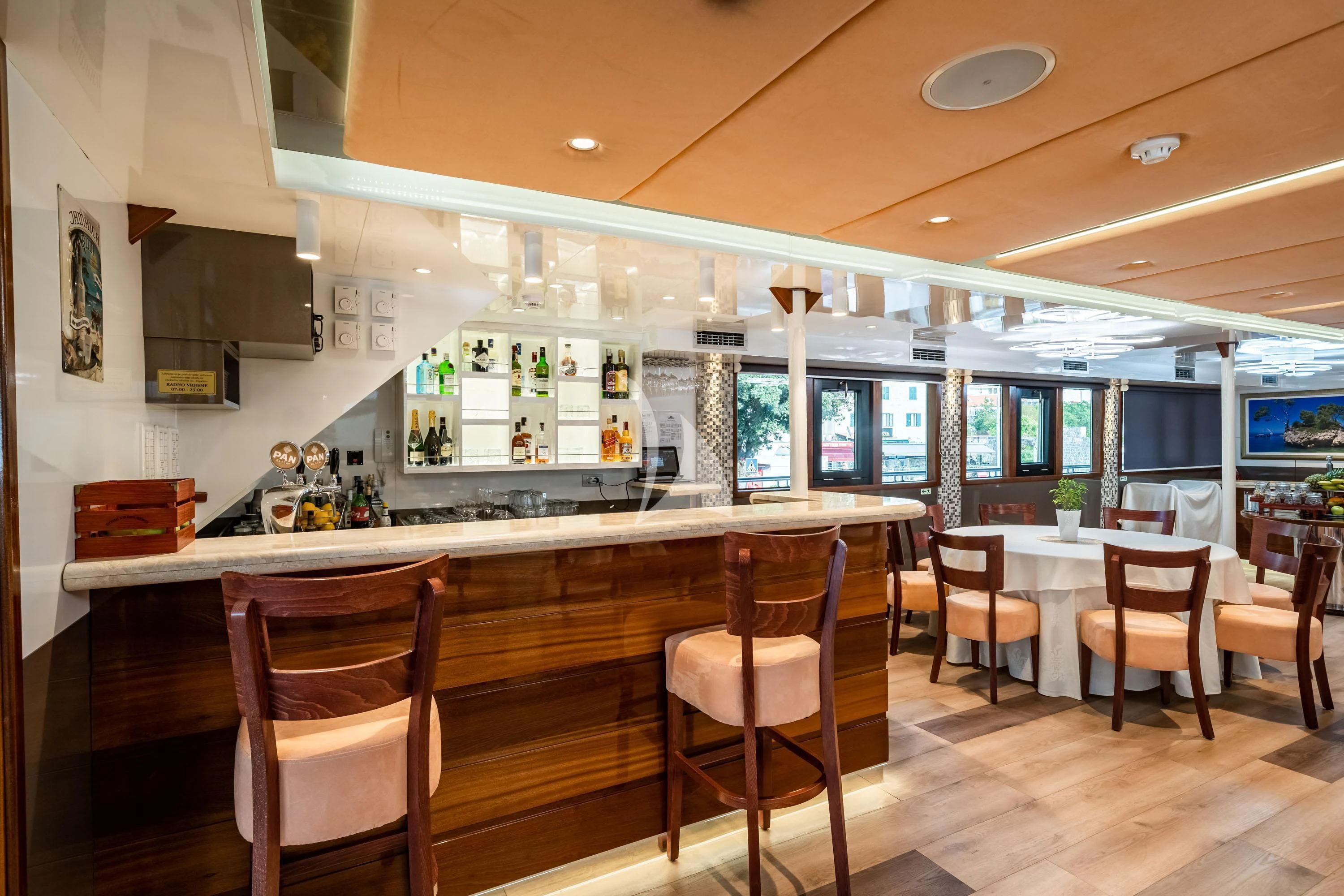 a kitchen with a bar and a table and chairs aboard QUEEN ELEGANZA Yacht for Sale