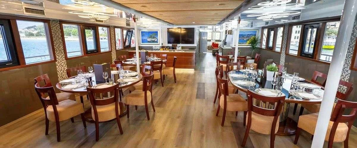 a room with tables and chairs aboard QUEEN ELEGANZA Yacht for Sale