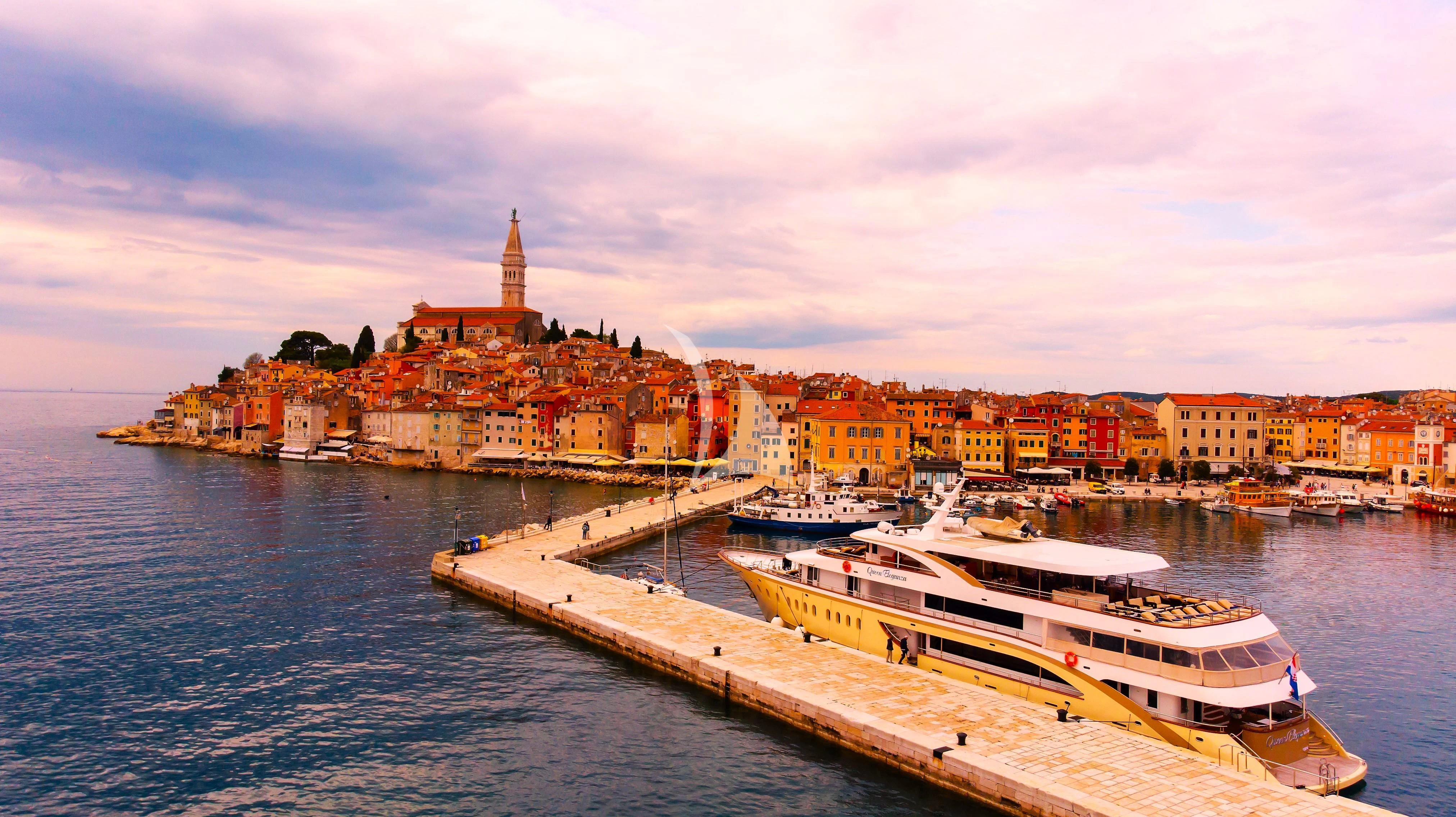 a city on a hill with a river and boats aboard QUEEN ELEGANZA Yacht for Sale